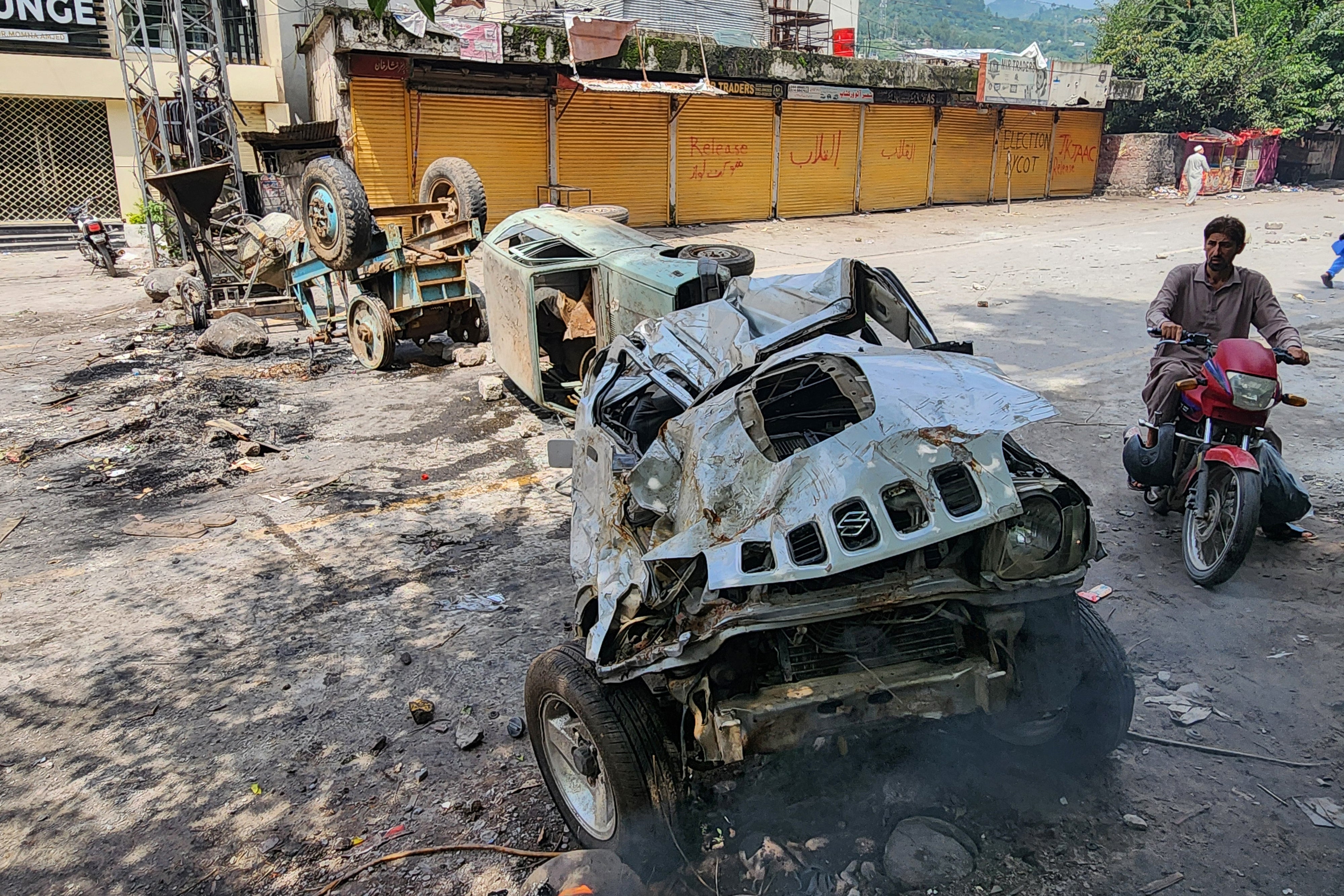 A motorcyclist rides along a blocked road following clashes between protesters and security personnel in Muzaffarabad on 1 August 2026