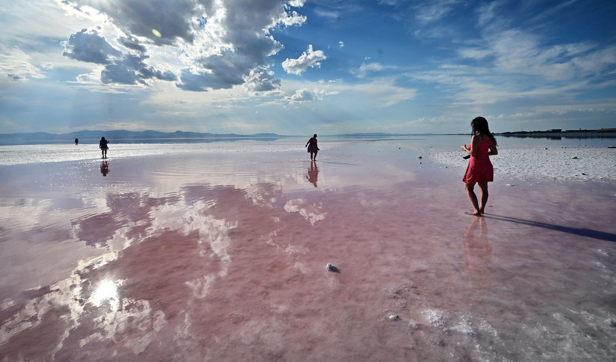People step into the pink water at the Great Salt Lake in Utah, in September 2024. Mosquitoes are particularly abundant around the lake and some traps have caught nearly 30,000 in a single night