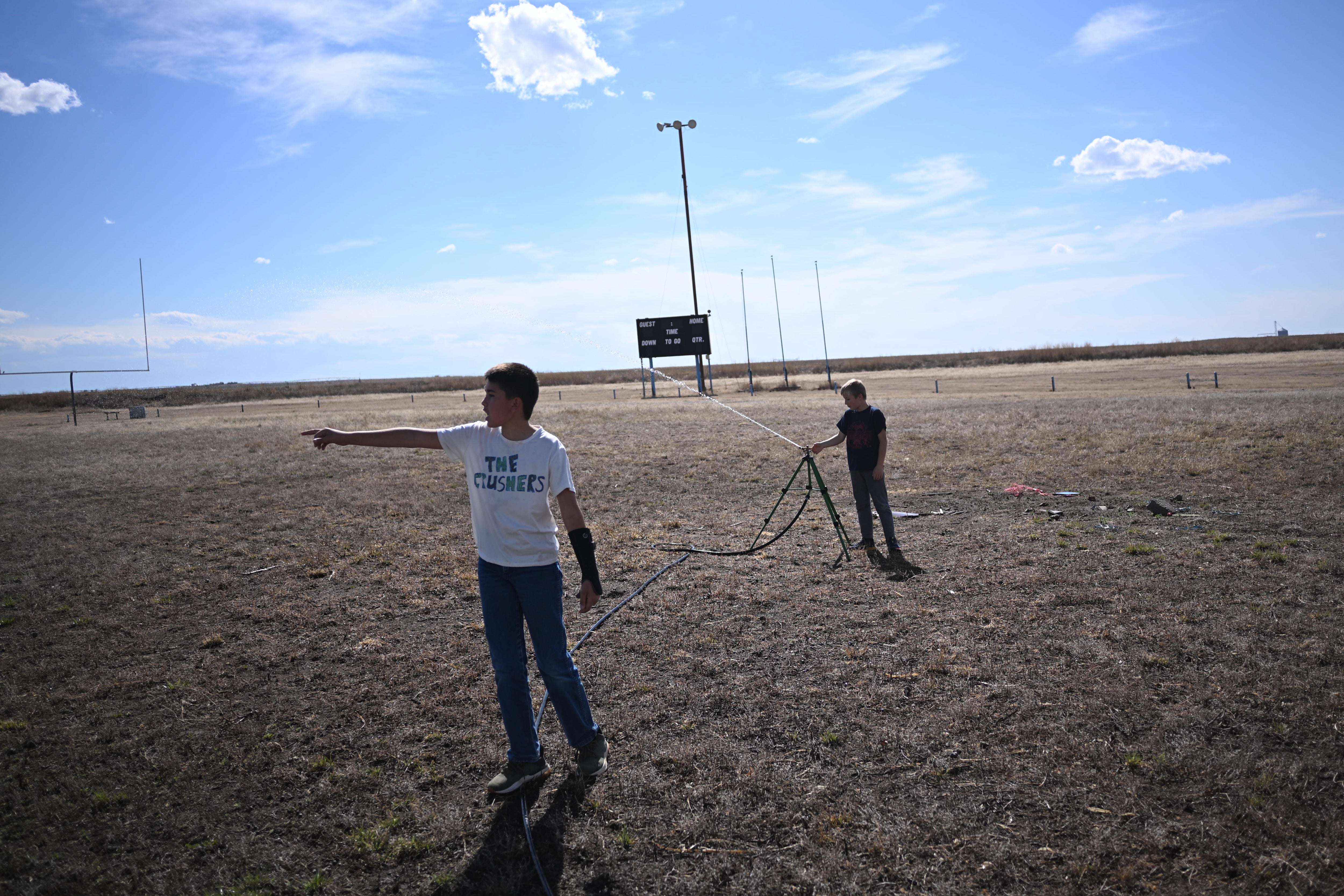 Kids play with the sprinkler on a drought-parched field in Vilas, Colorado, in May. The state has seen fewer mosquitoes this year, but more cases of West Nile virus following the spring’s historic drought