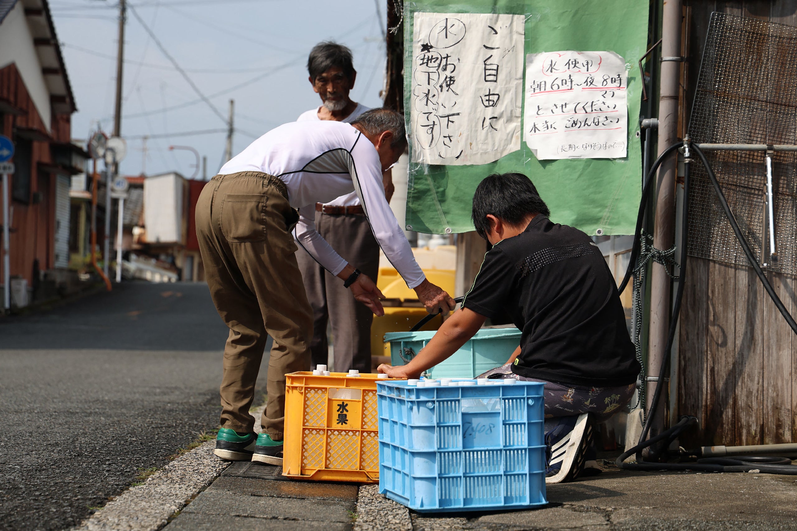 People collect water from a tap in the aftermath of the earthquake
