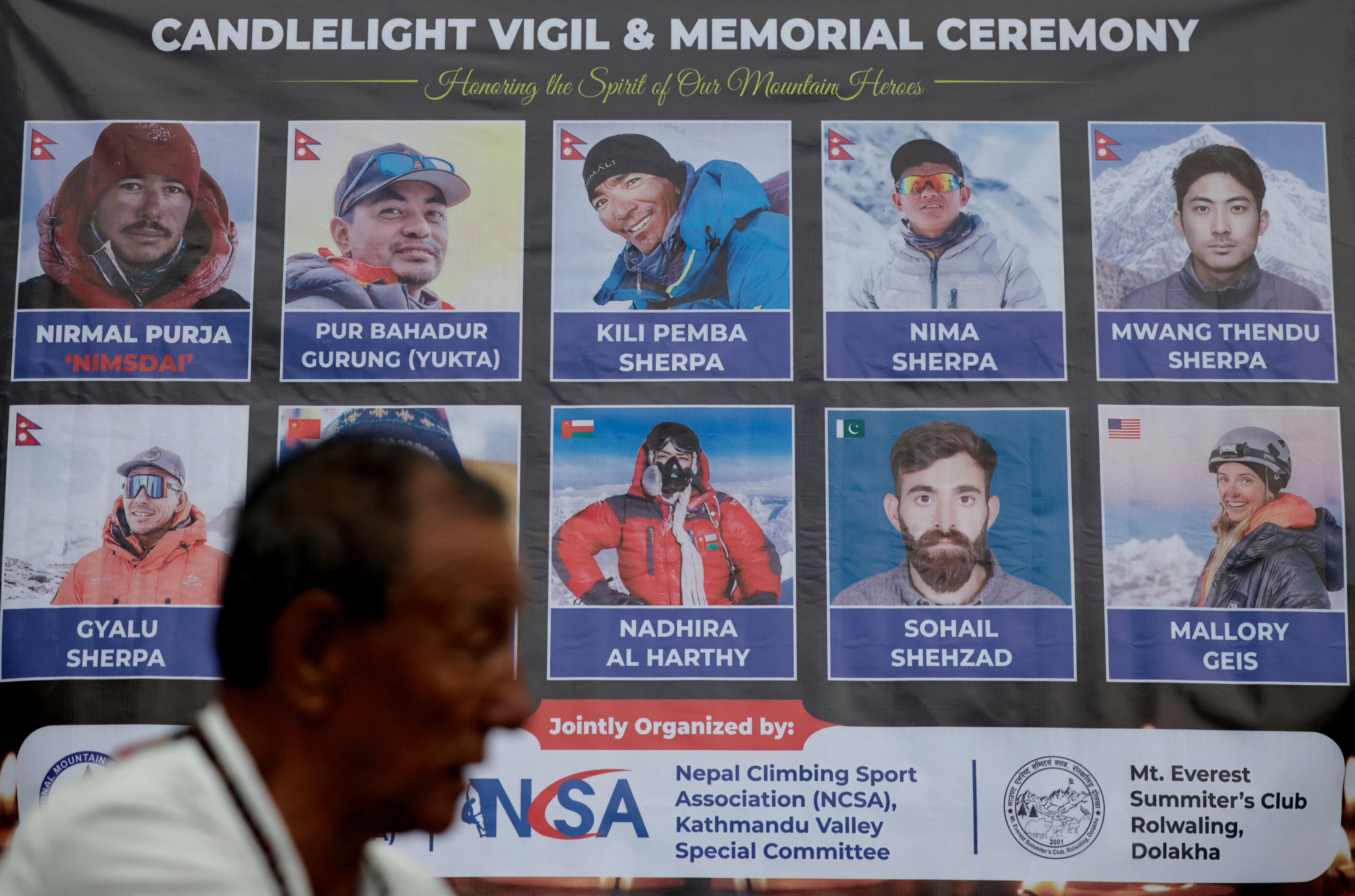 A man stands in front of the portraits of climbers who lost their lives in an avalanche while summiting Broad Peak in Pakistan during a vigil to honour climbers in Kathmandu, Nepal, 4 August 2026 (Reuters)