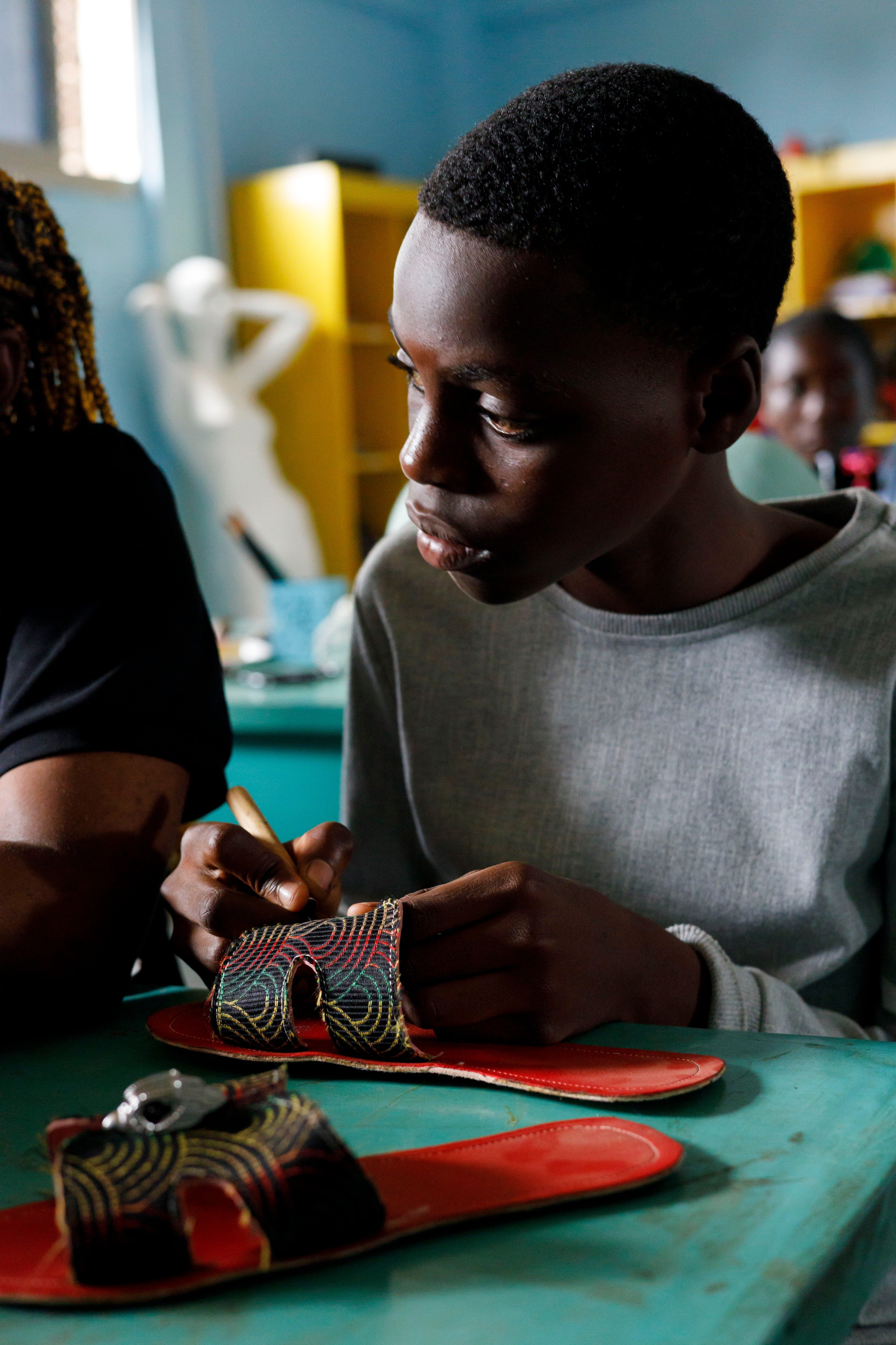A student at The Creative Corner learns the art of shoemaking, carefully stitching each piece by hand as part of a programme that teaches every stage of the making process. (Copyright:  The Creative Corner)
