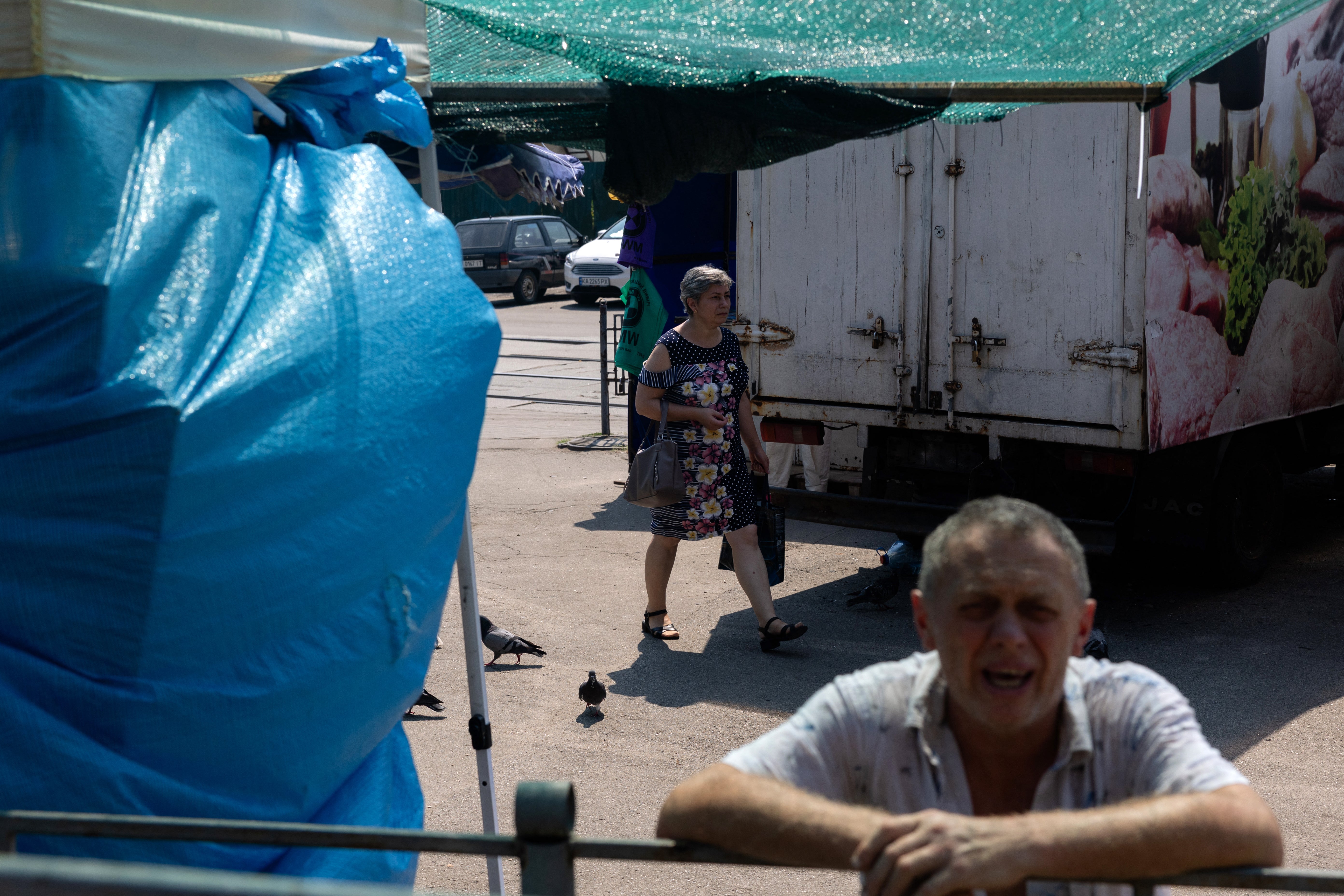 A woman walks in a damaged street market following Russian strikes in Kyiv on 6 August 2026, amid the Russian invasion of Ukraine (AFP/Getty)