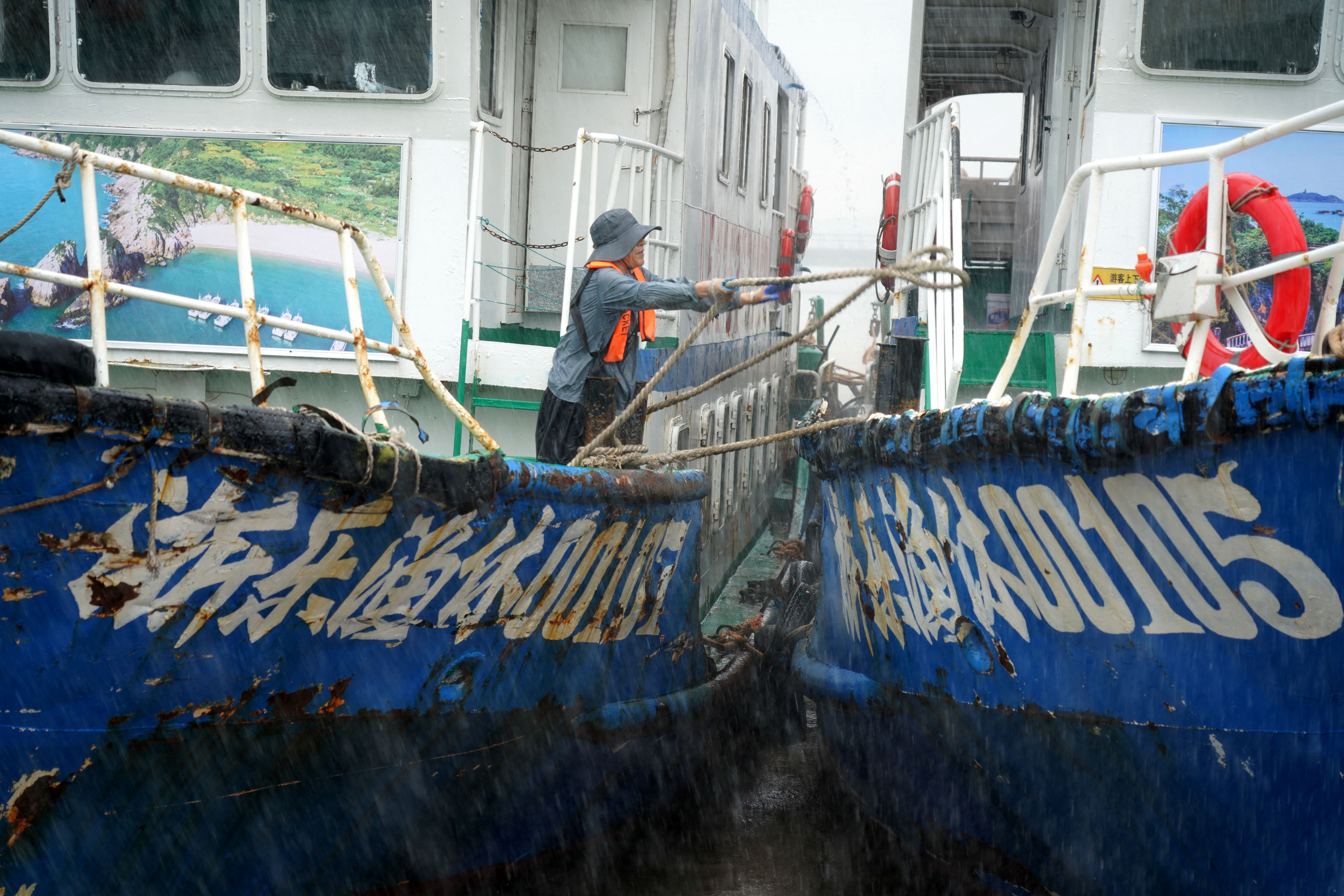 Crew member secures boats at Nanyue Pier as Typhoon Dolphin approaches, in Yueqing Bay (Reuters)