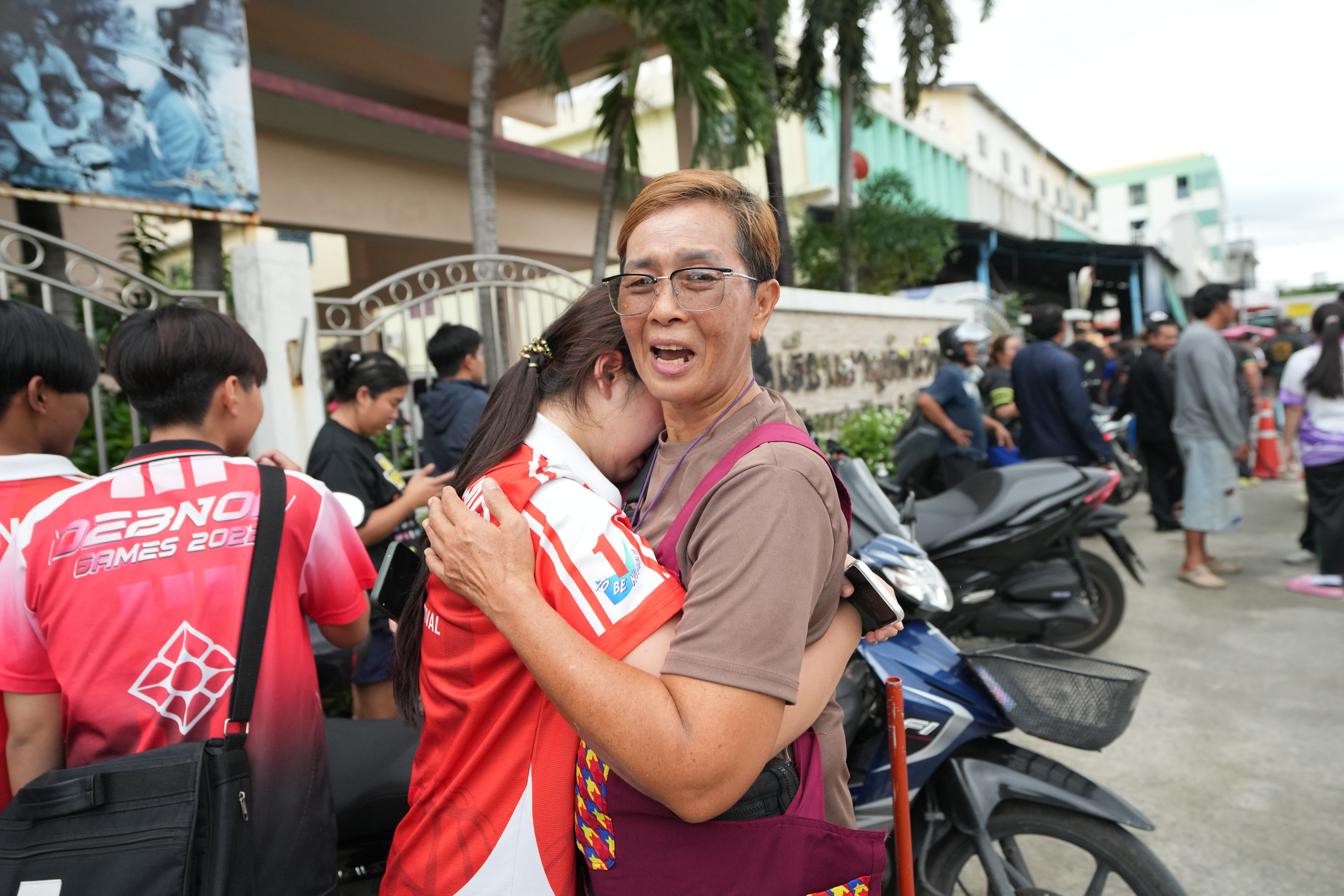 A schoolgirl cries outside her school where deaths and injuries were reported after a shooting in Thailand's Nonthaburi province, Friday