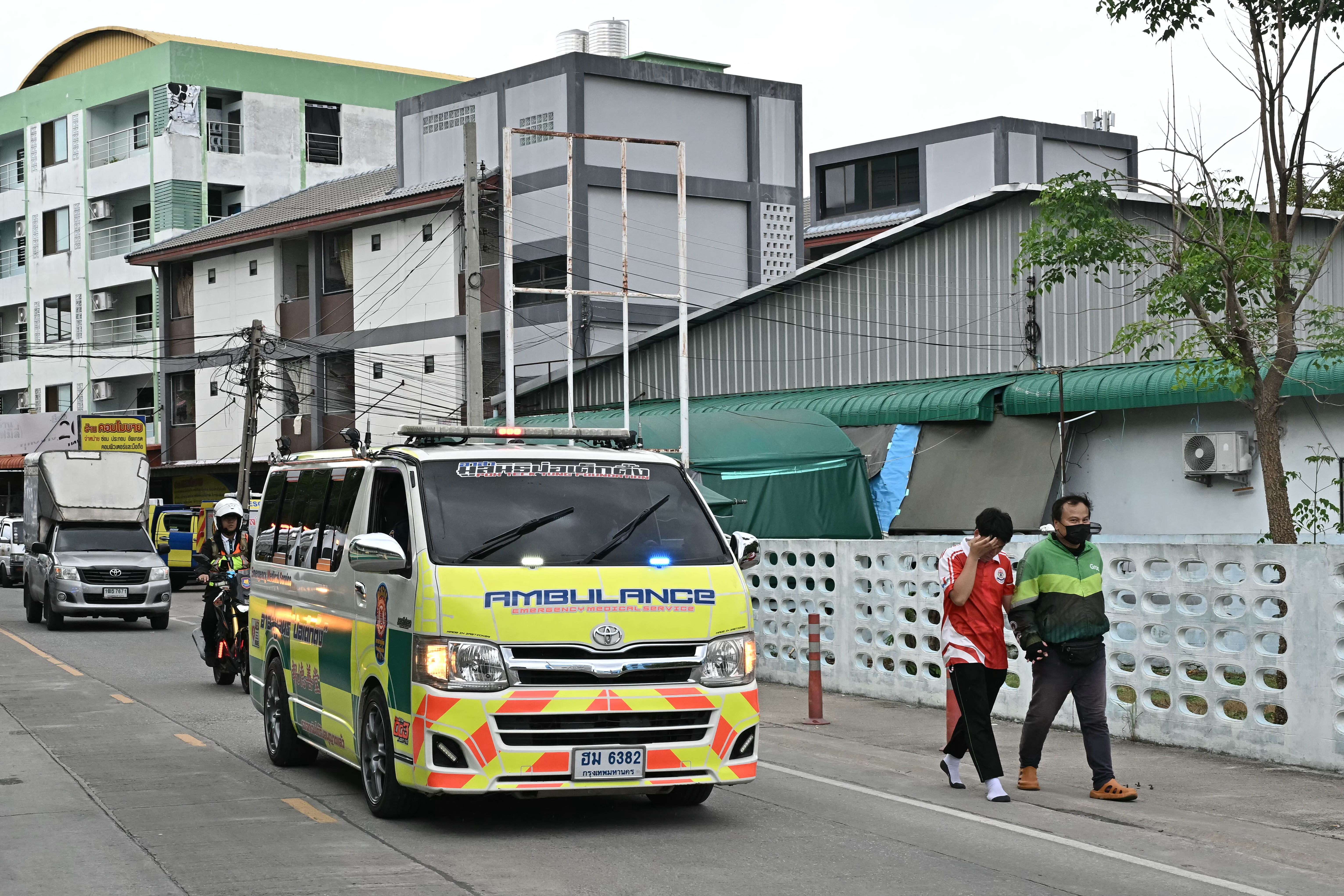A student leaves with a parent (R) as an ambulance drives past after a school shooting in Bang Kruai district, Nonthaburi province, north of Thailand's capital Bangkok, on August 7, 2026