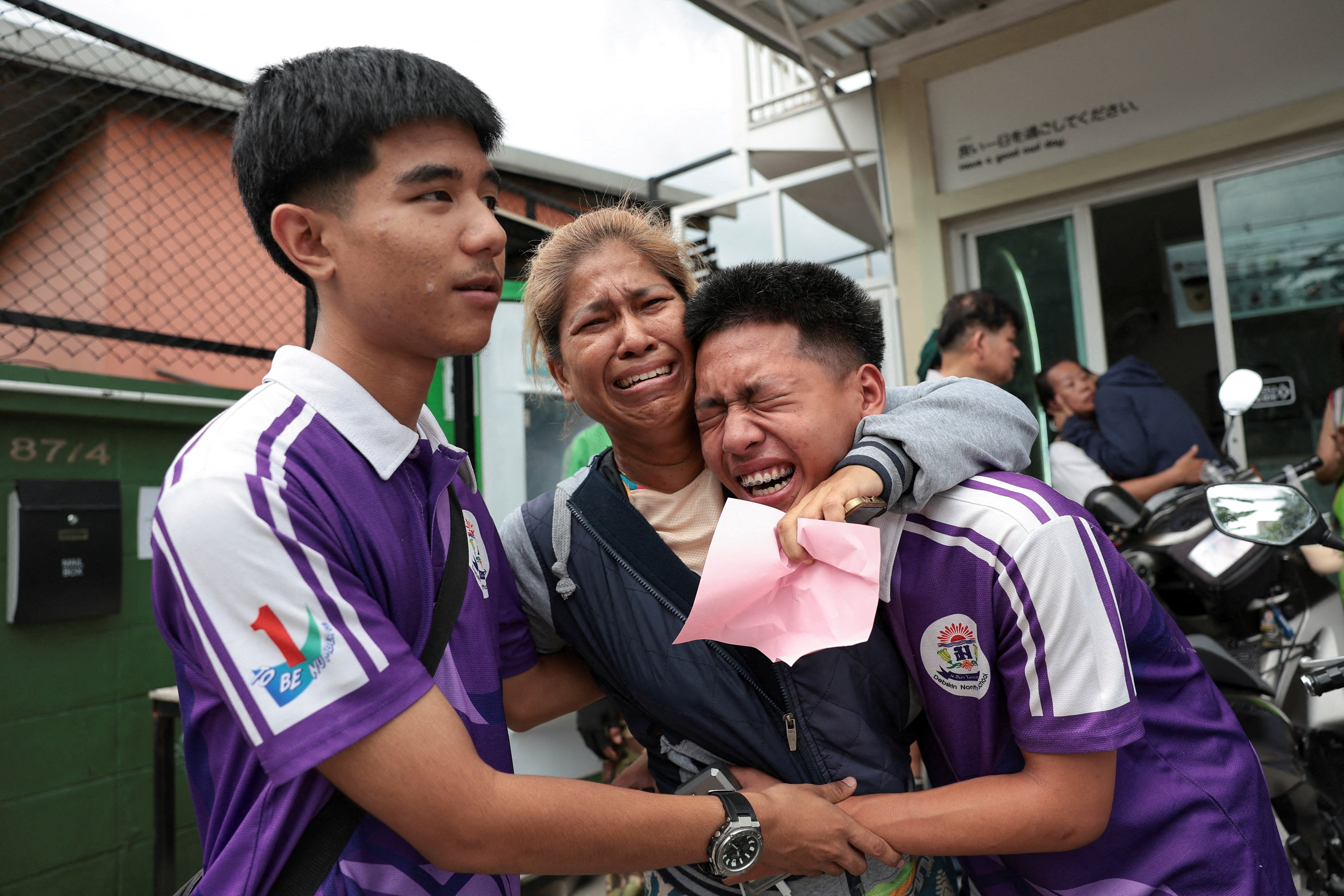 Students react with a relative after being evacuated from Debsirin Nonthaburi School