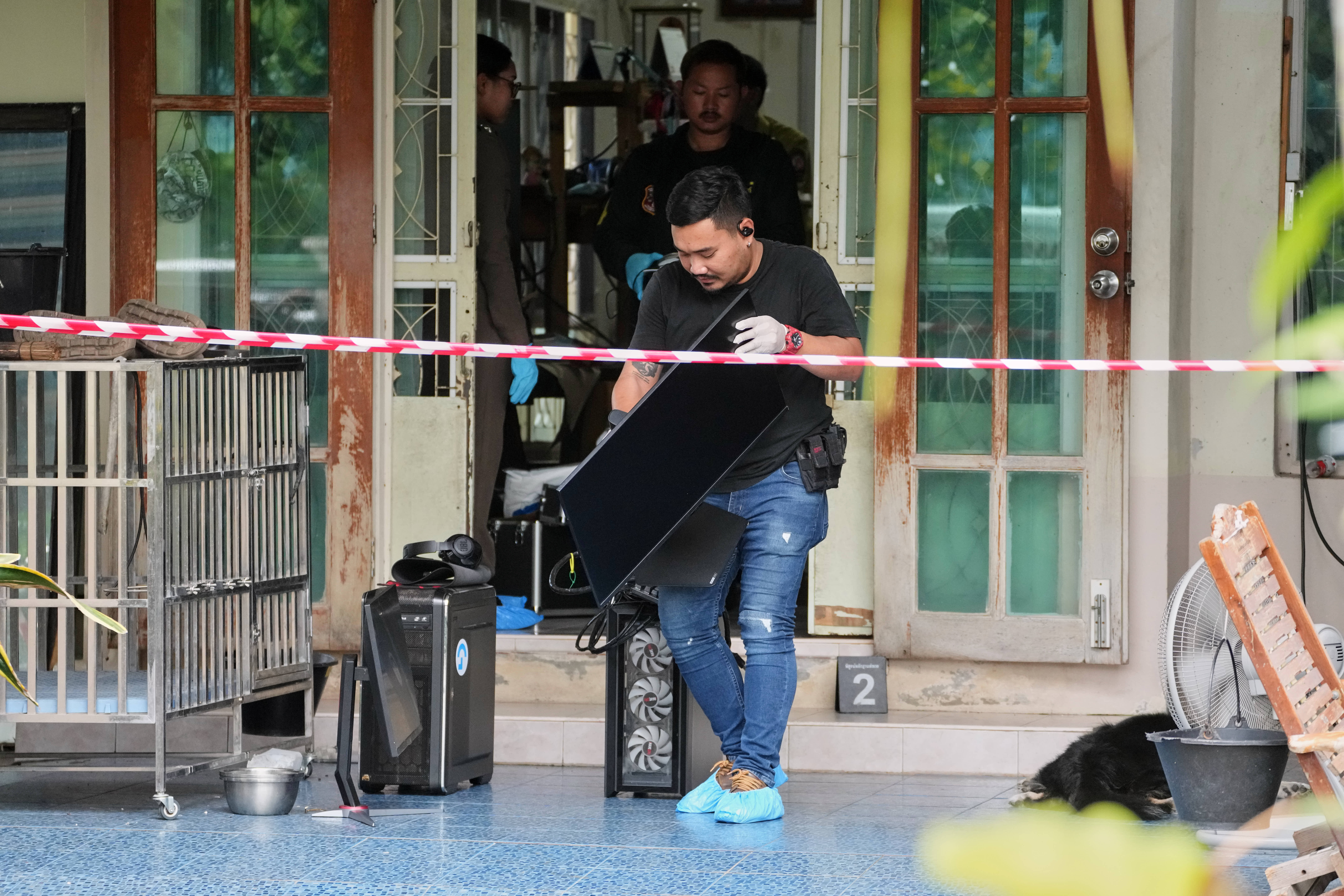 Police take away computers from the home of a student who shot several people