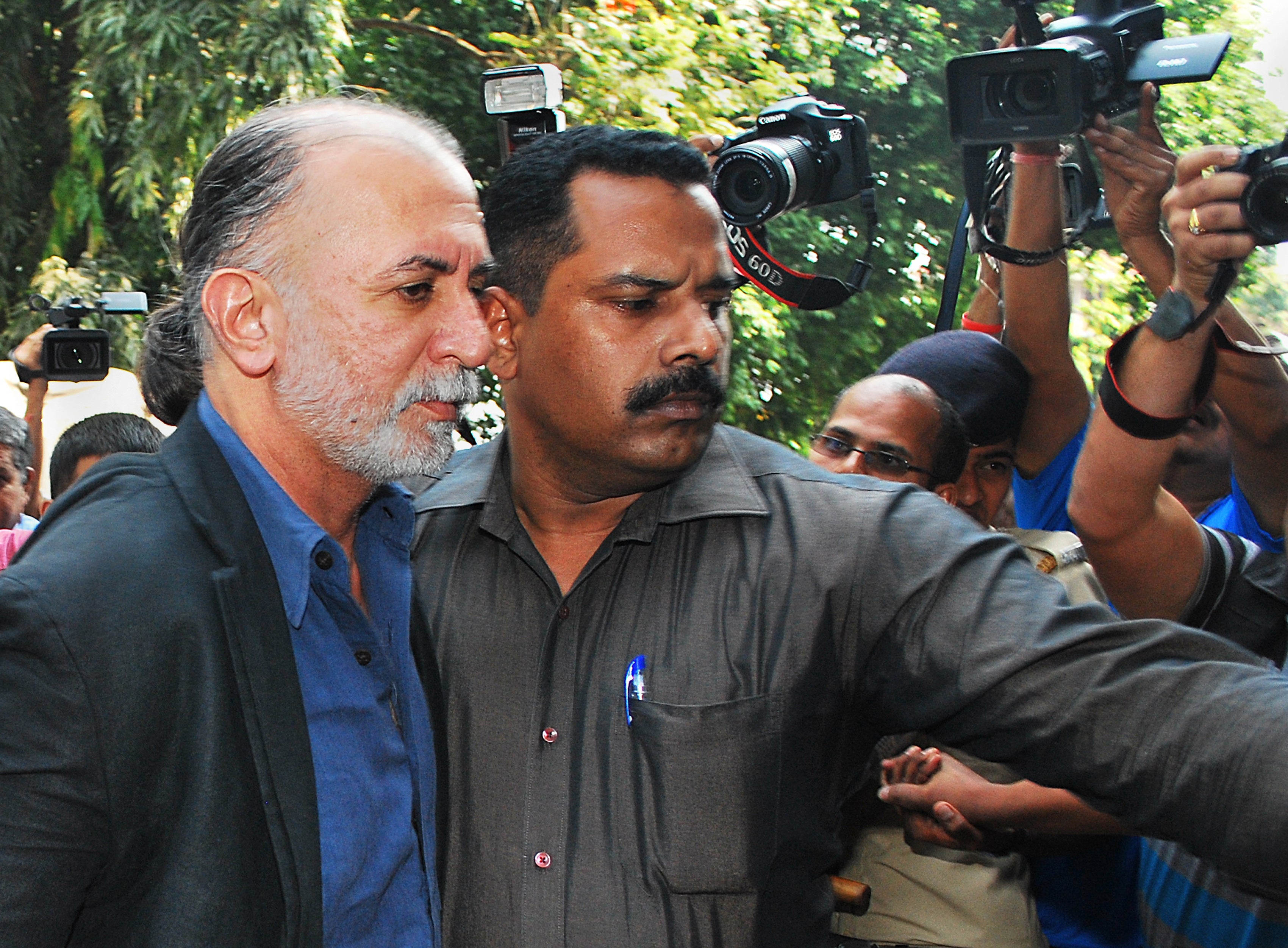 Tarun Tejpal is escorted by police officials from a courthouse after being remanded in police custody in Panaji in 2013 (AFP/Getty)