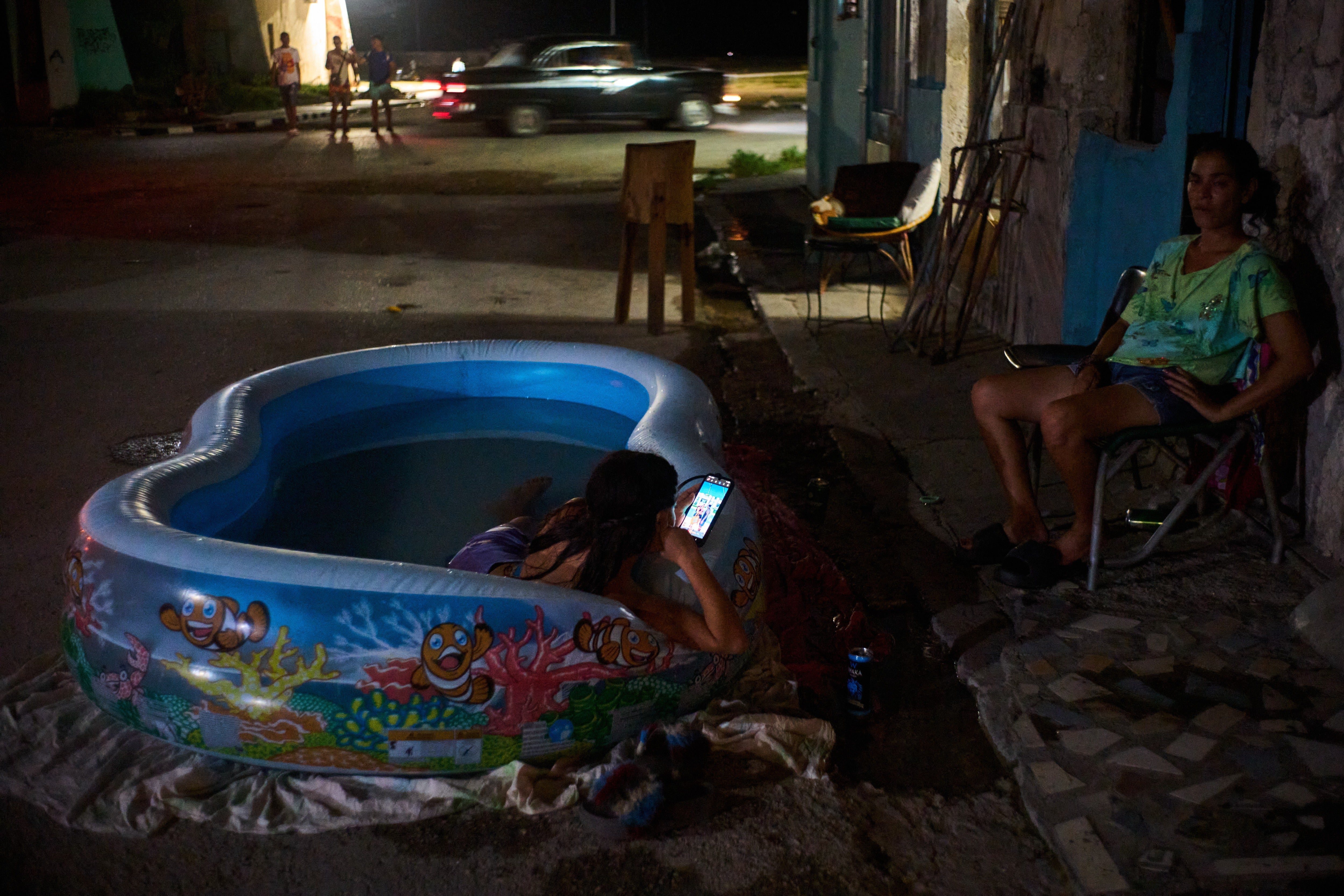 A girl cools off in a plastic pool in the street in Havana (AP Photo/Ramon Espinosa)