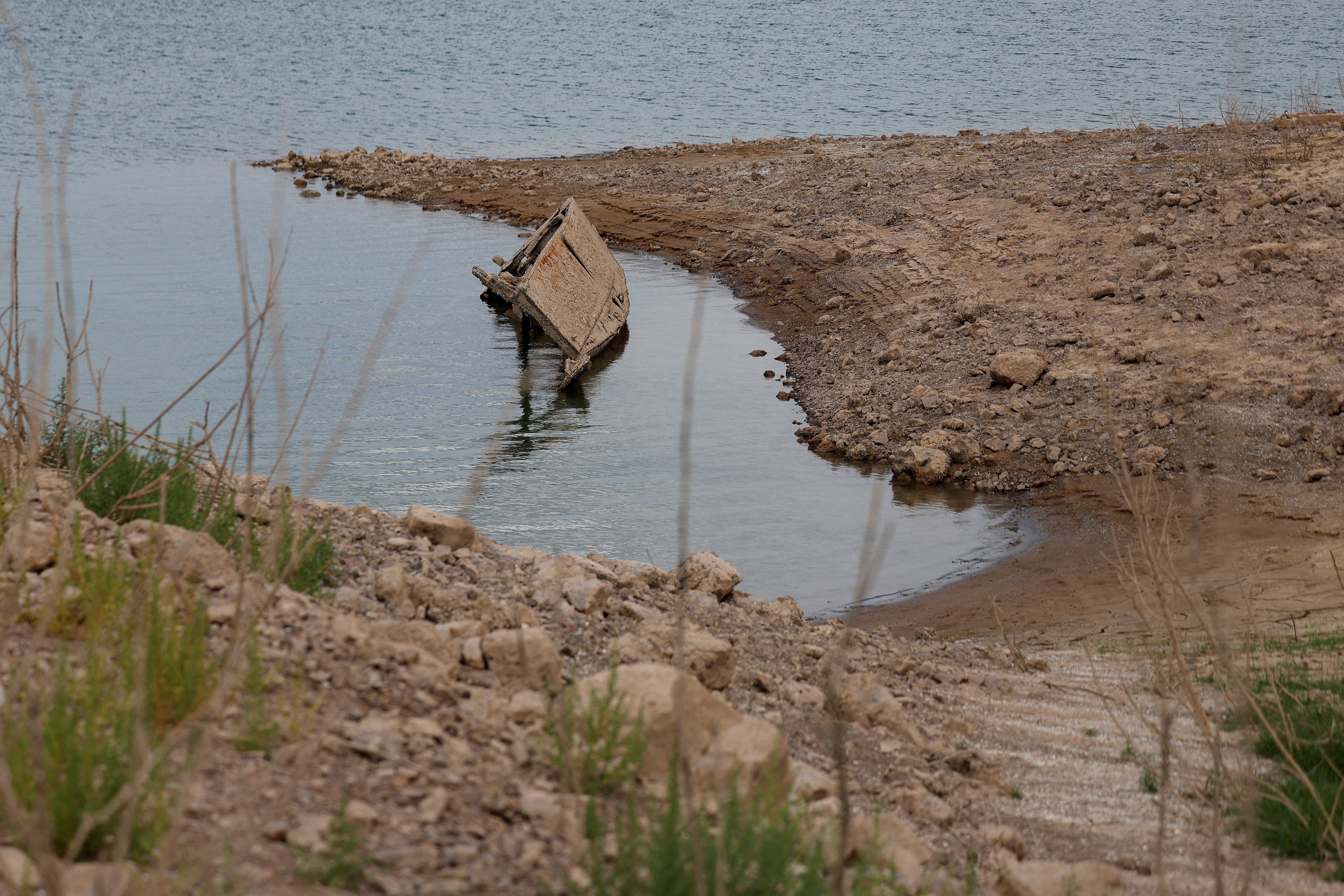As water levels drop, the receding water exposes hidden shorelines, old rocks, land and objects that stayed underwater for decades