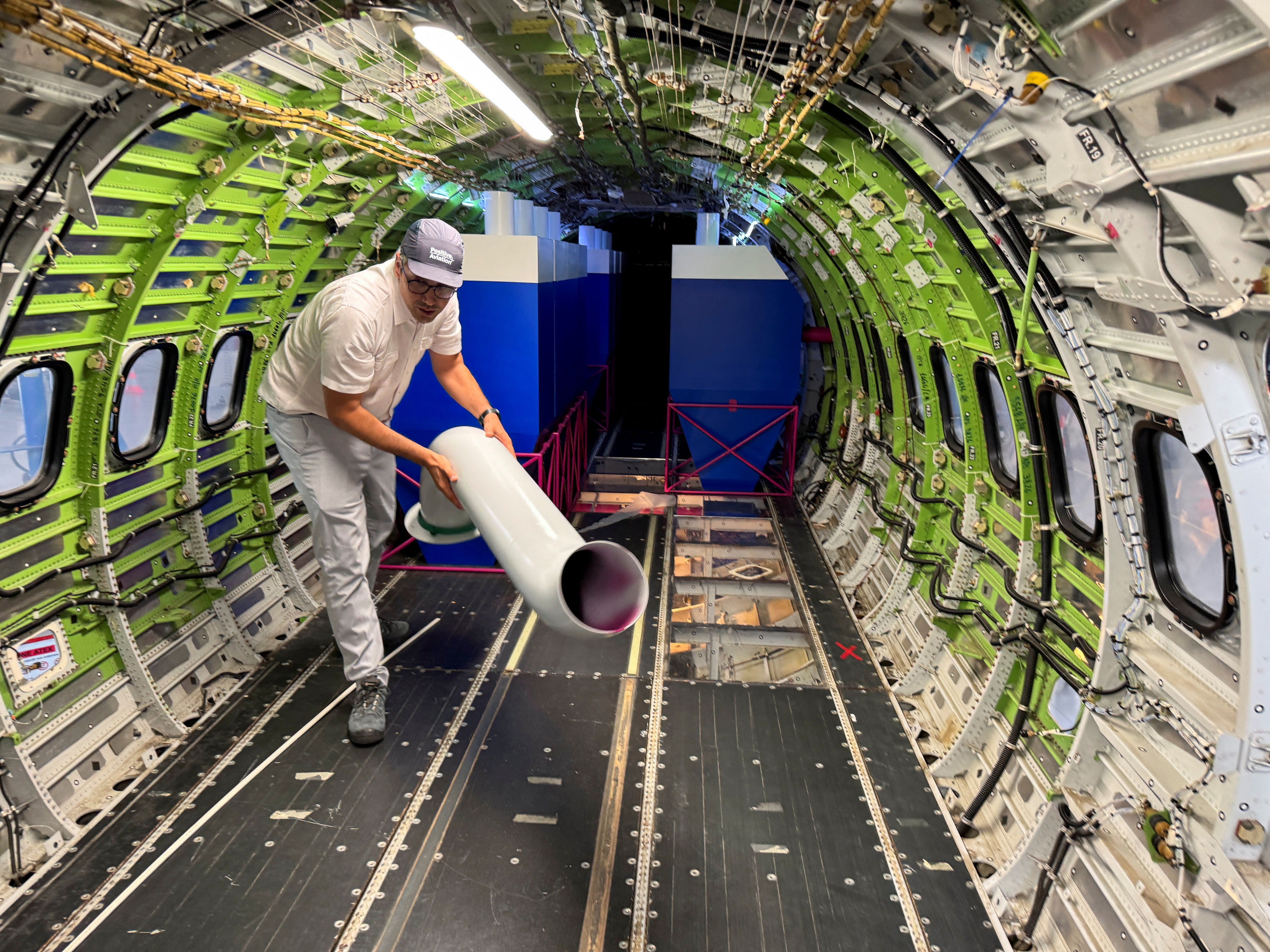 Jonathan Beck, head of overall aircraft design at Positive Aviation, handles a component of a water-scooping system on a converted ATR-72 firefighting demonstrator,