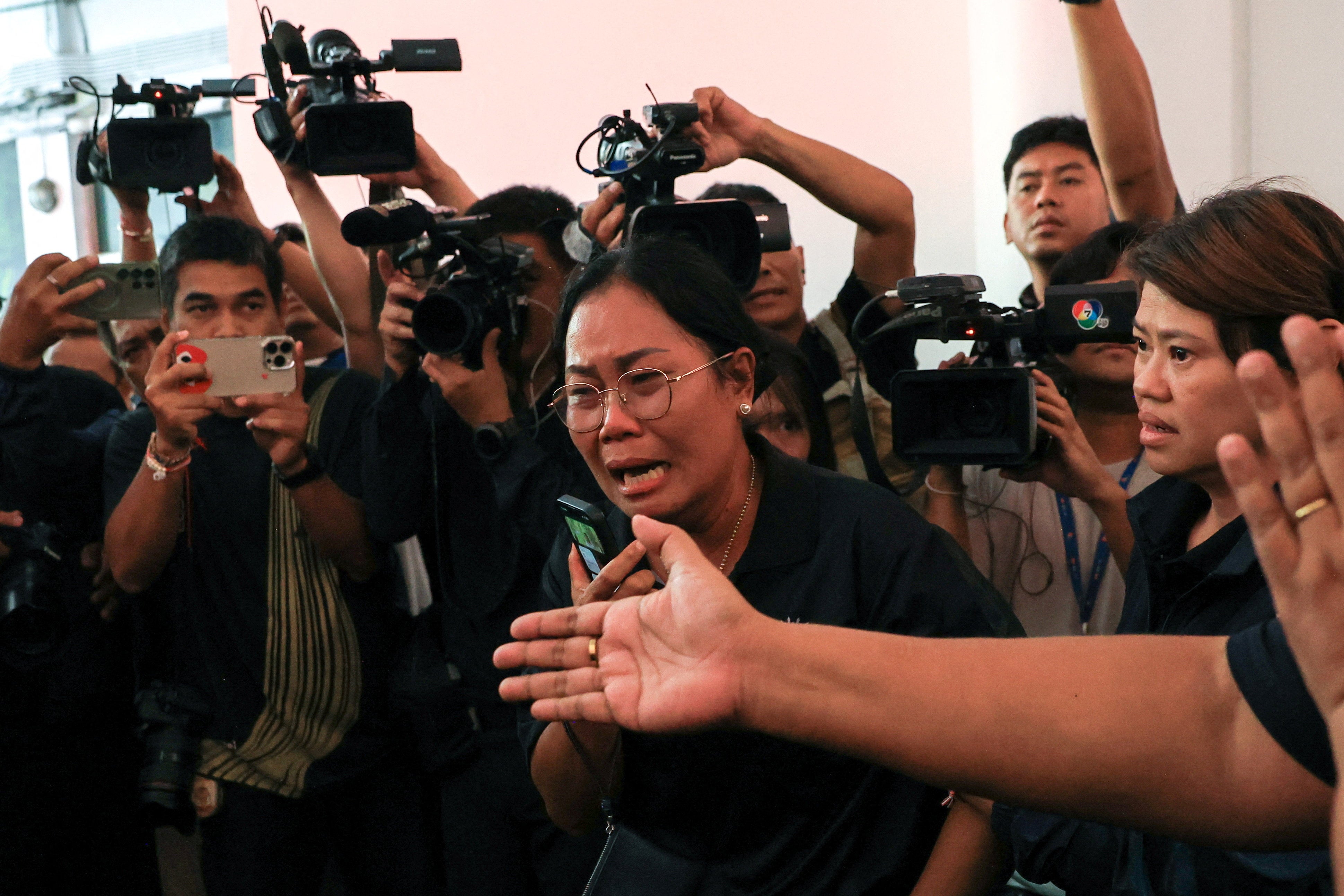 A family member of a teacher killed in a deadly shooting at Debsirin Nonthaburi School, reacts as the body is received at Police General Hospital, in Bangkok, Thailand, August 8, 2026. REUTERS/Valeria Mongelli