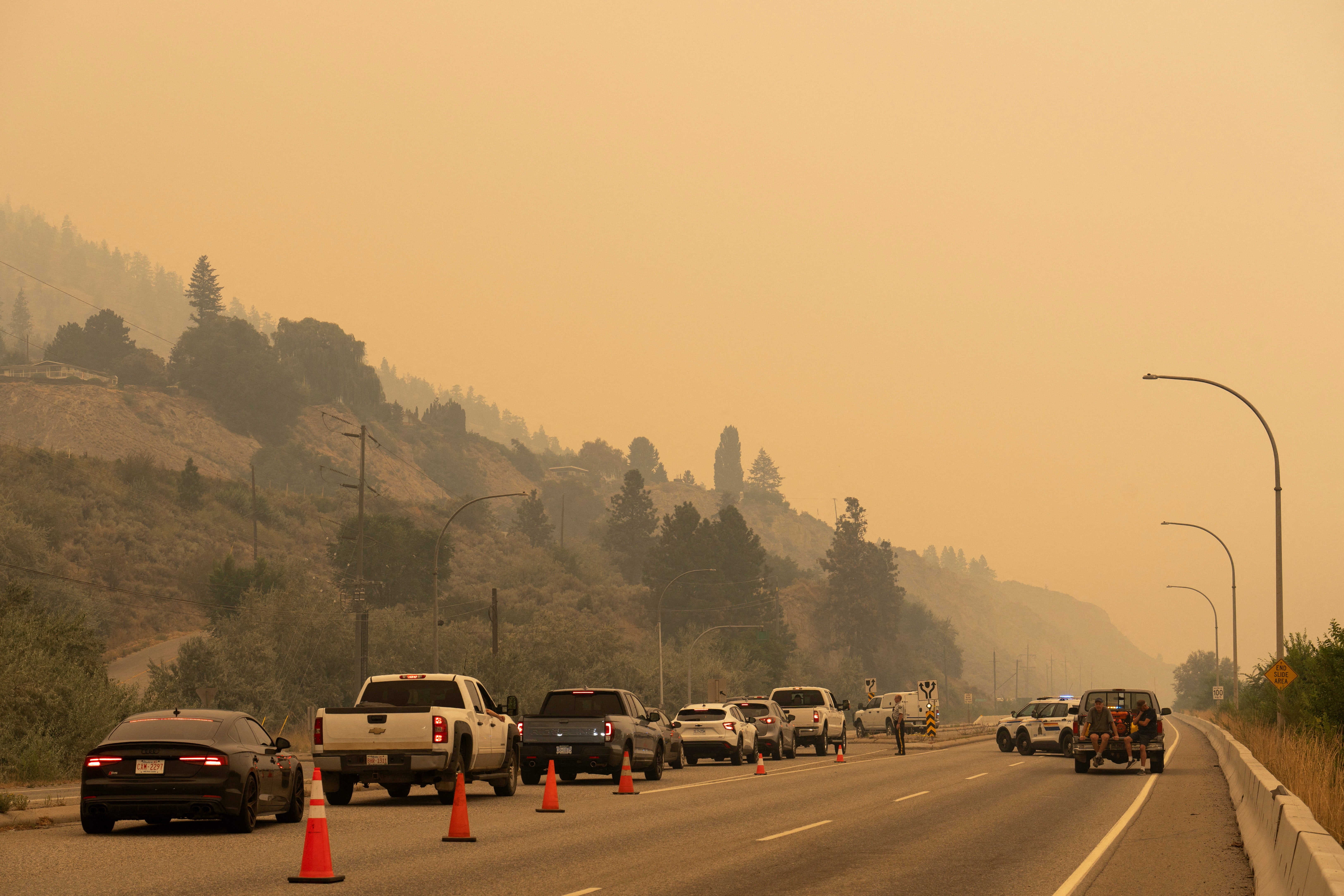 The Royal Canadian Mounted Police (RCMP) block Highway 97 Northbound to direct people away from the Bald Range wildfire