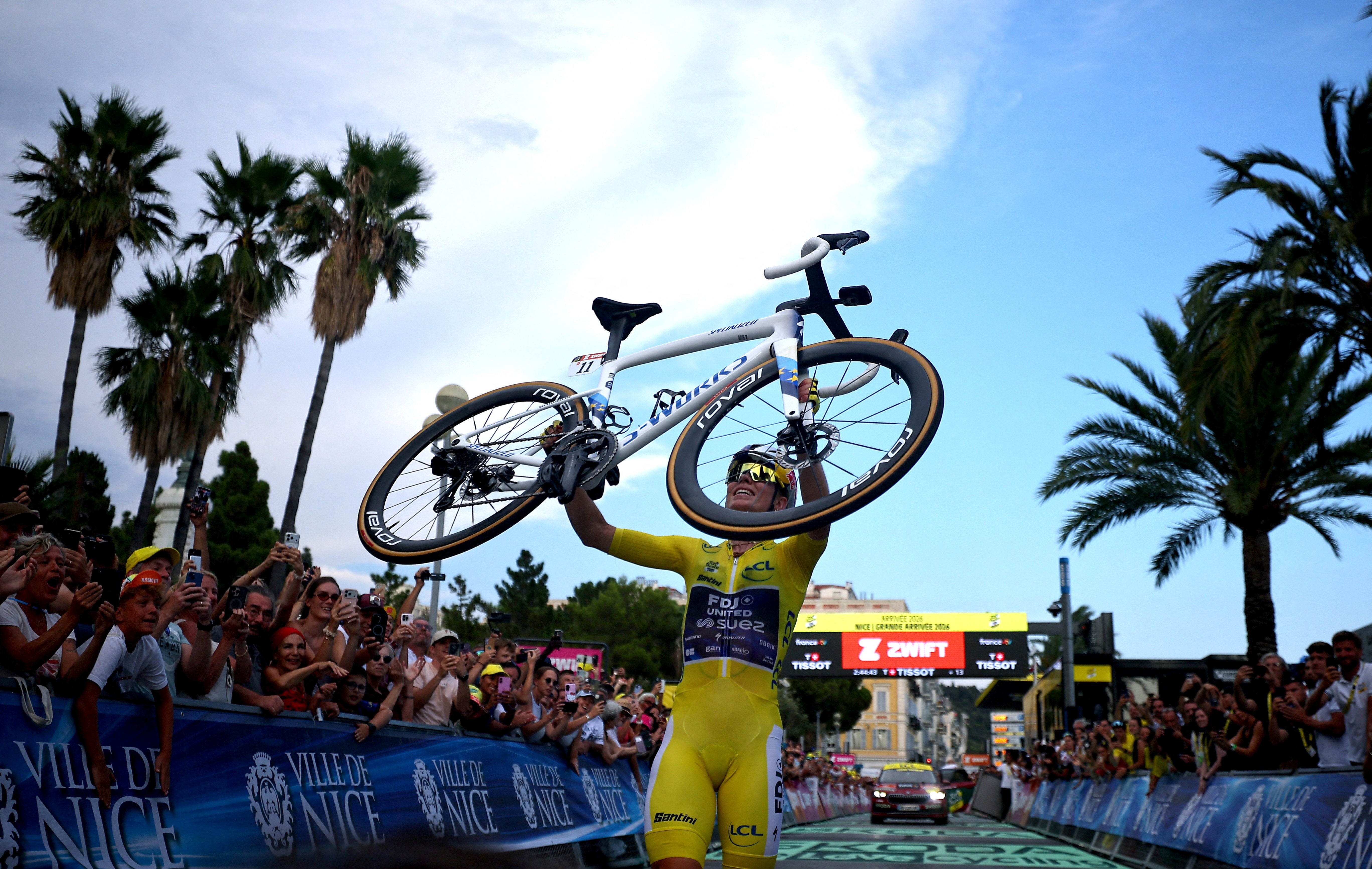 Demi Vollering lifted her bike in celebration at the finish line (Reuters)