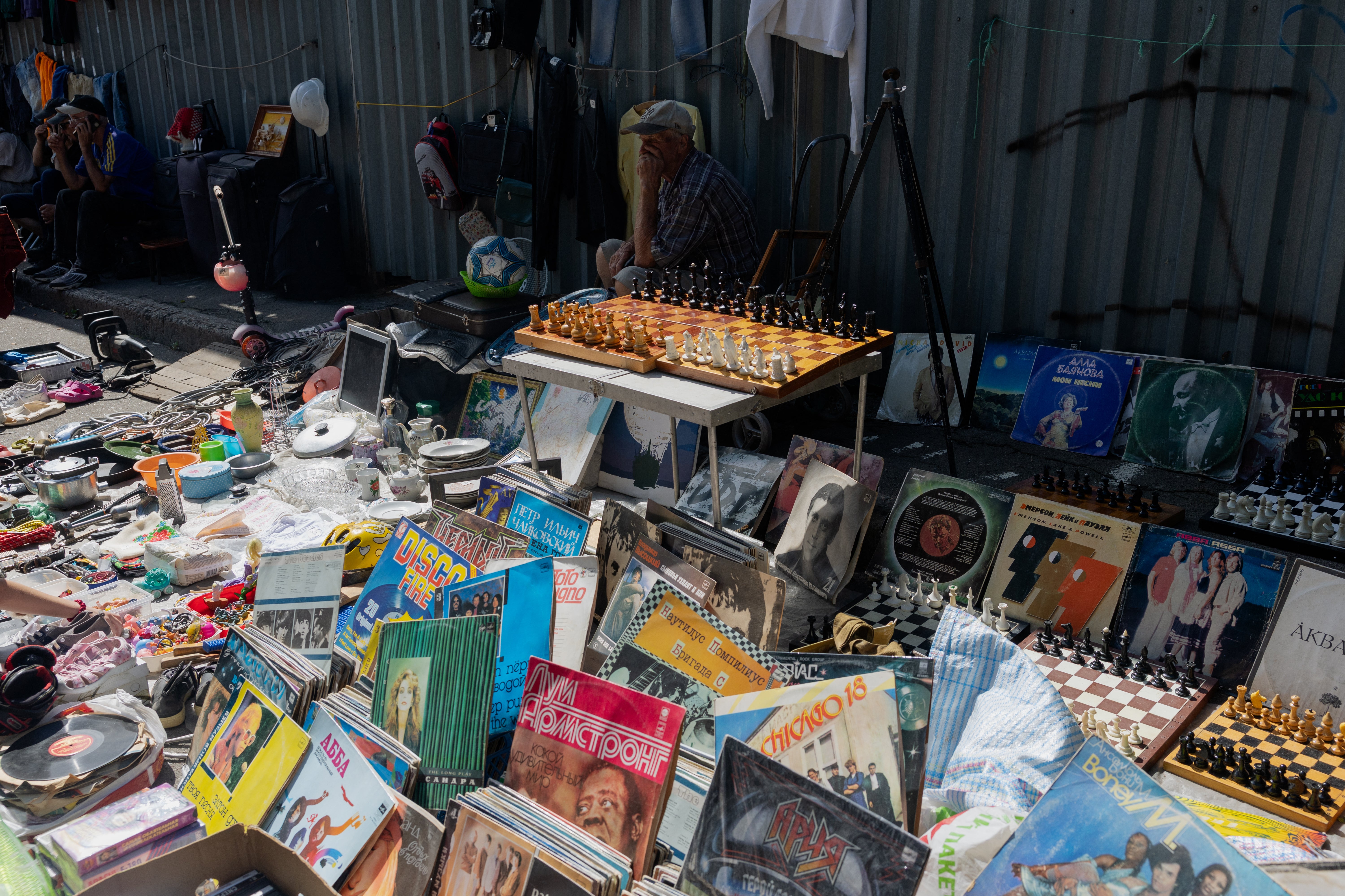 A vendor selling vinyl records sits at a damaged street market following Russian strikes (AFP/Getty)