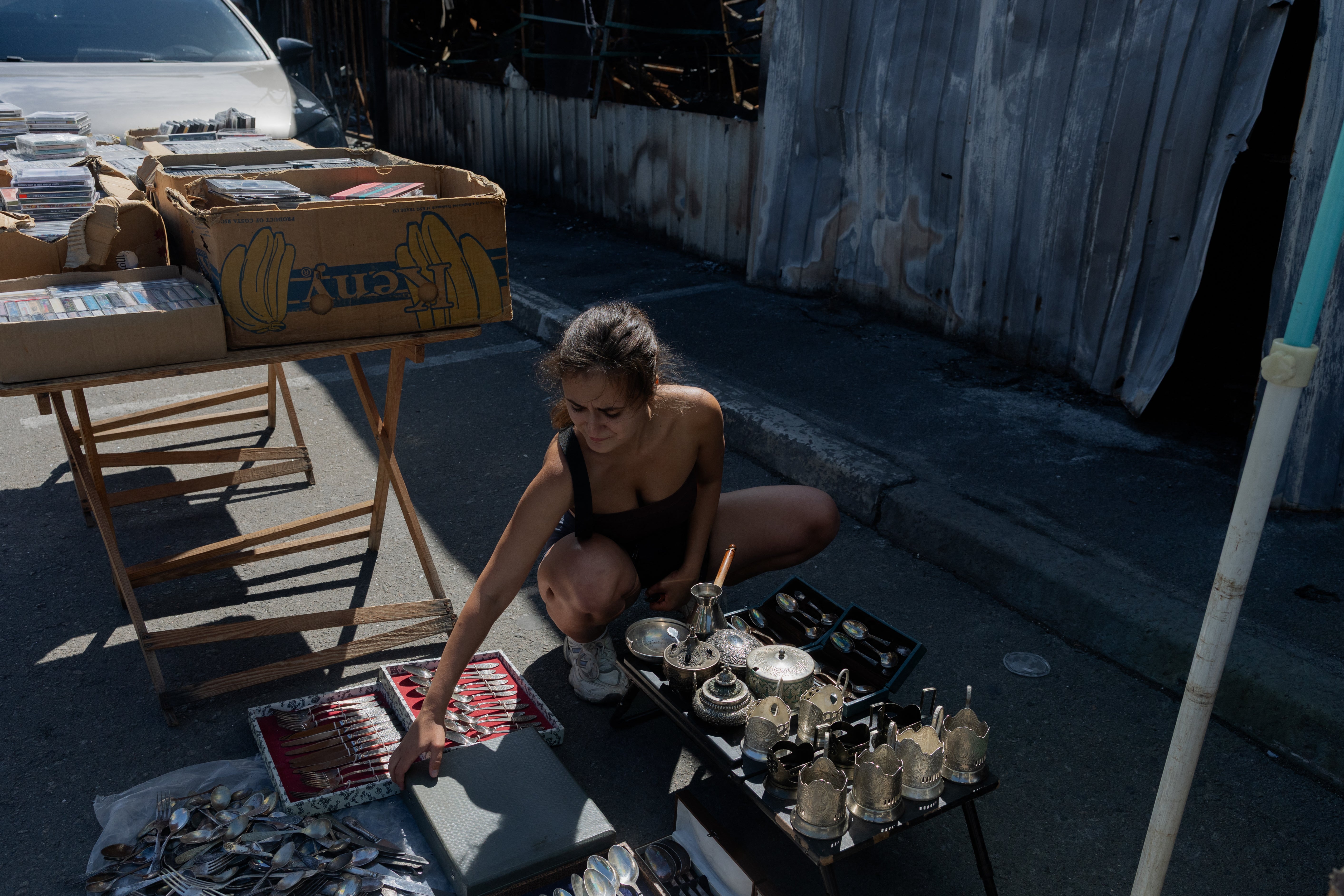 A saleswoman sells cutlery and silverware at a damaged street market following strikes in Petrivka, one of Kyiv's neighborhoods (AFP/Getty)