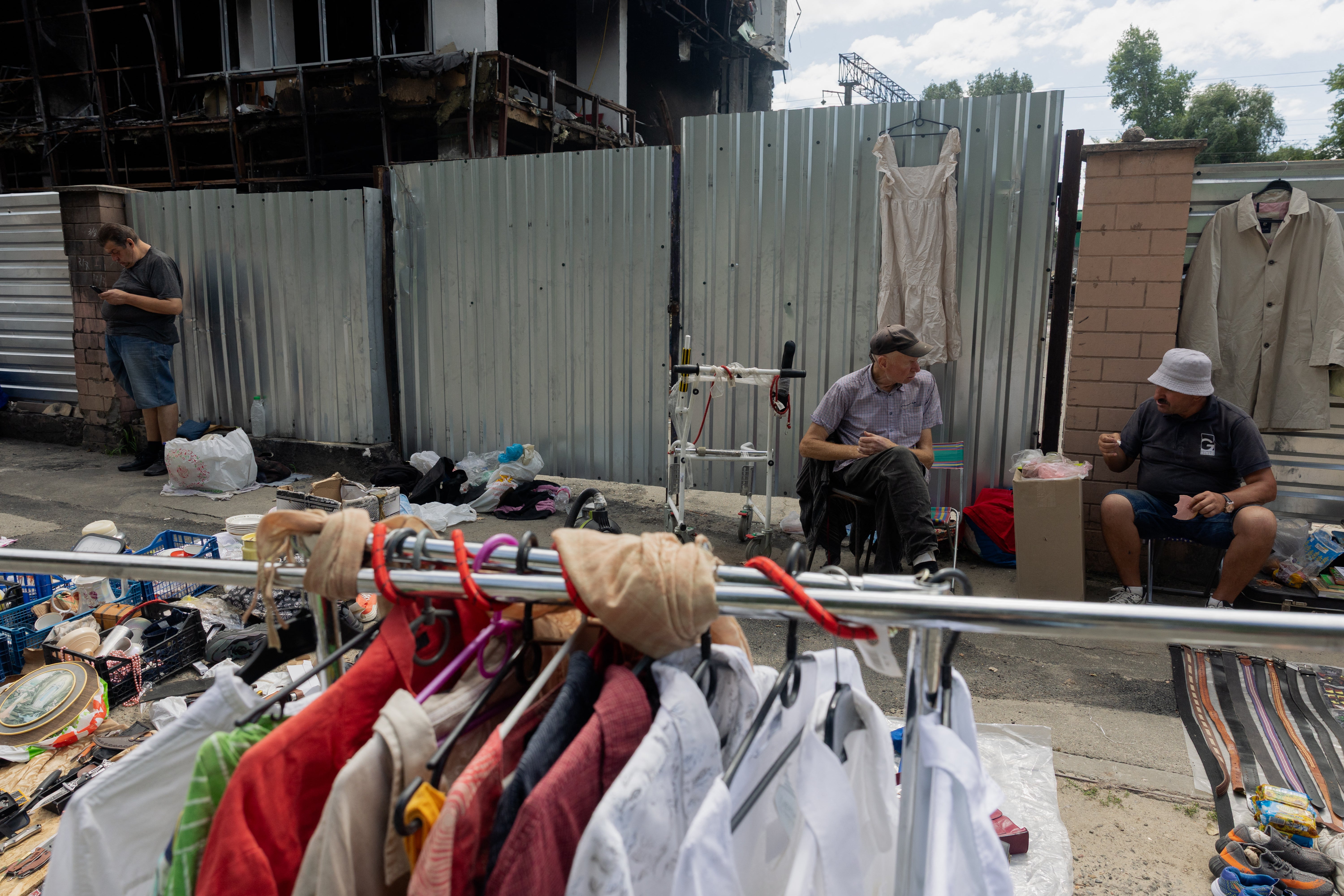 Vendors sit in front of their stalls at a damaged street market following strikes in Petrivka, one of Kyiv's neighborhoods (AFP/Getty)