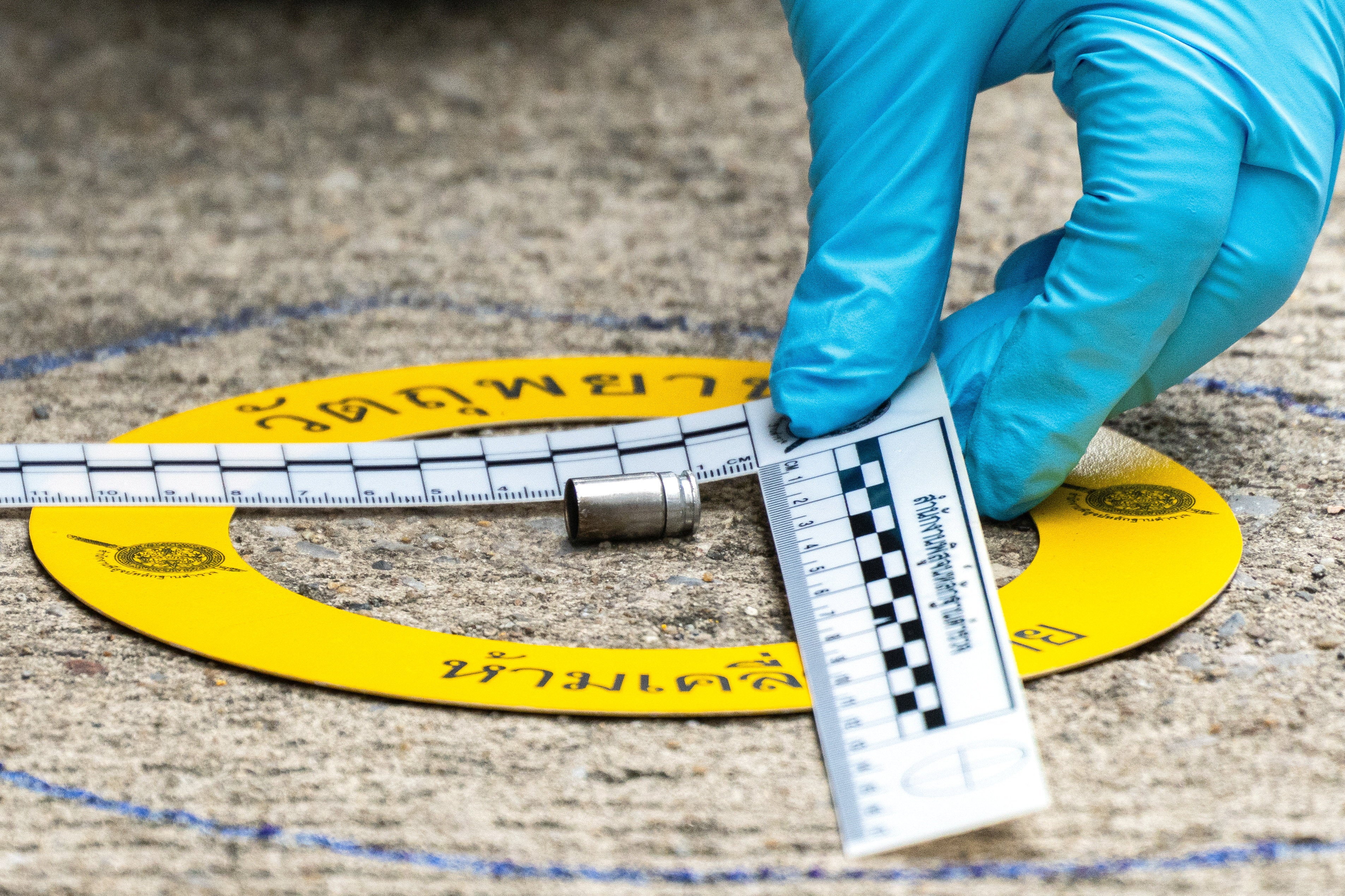 A forensic police officer inspects the site of a shooting after former lawmaker Chalong Riewrang allegedly shot Thongchai Yenprasert, president of the Nonthaburi Provincial Administrative Organisation (Reuters)