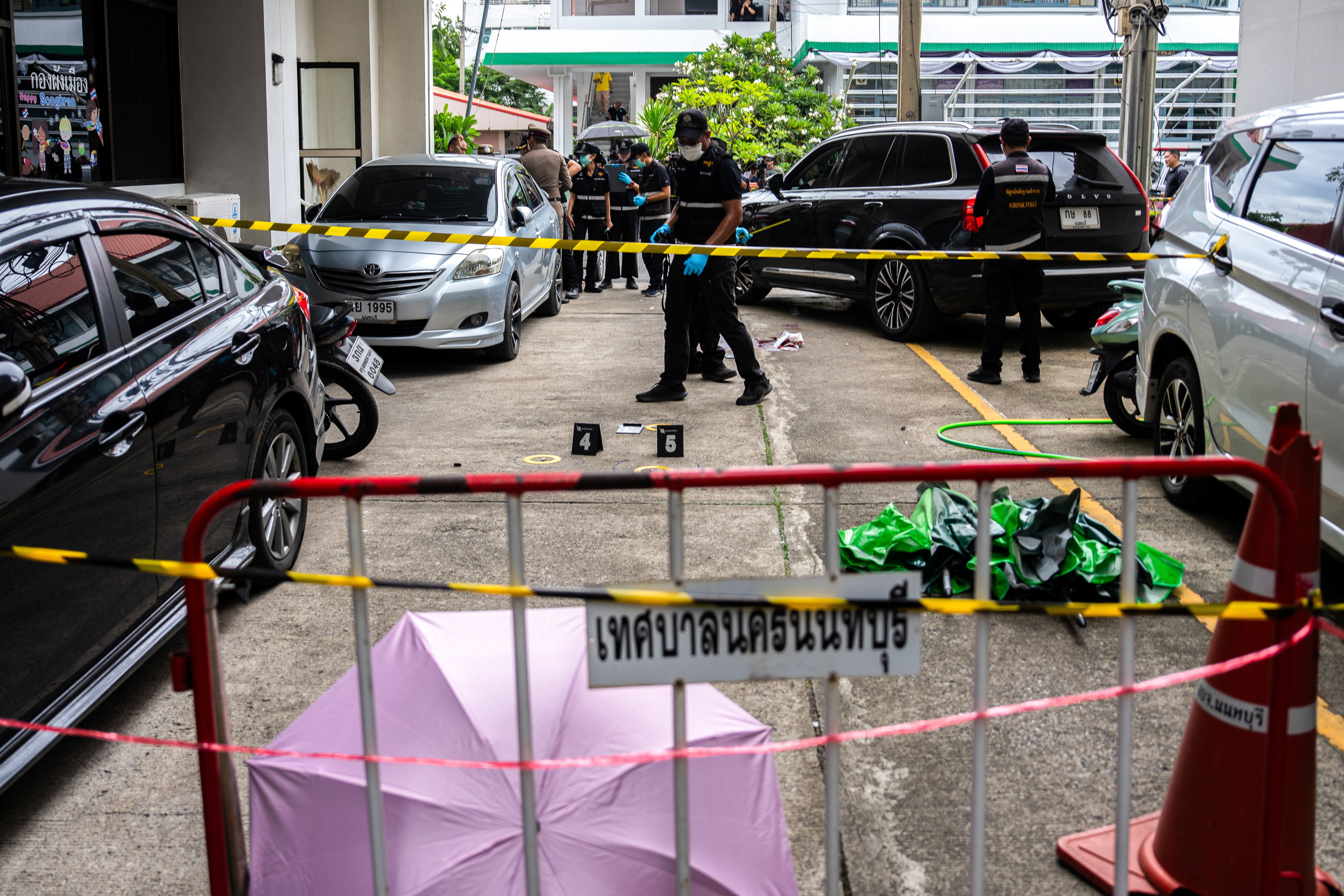 Forensic police officers inspect the site of a shooting after former lawmaker Chalong Riewrang allegedly shot Thongchai Yenprasert, president of the Nonthaburi Provincial Administrative Organisation (Reuters)