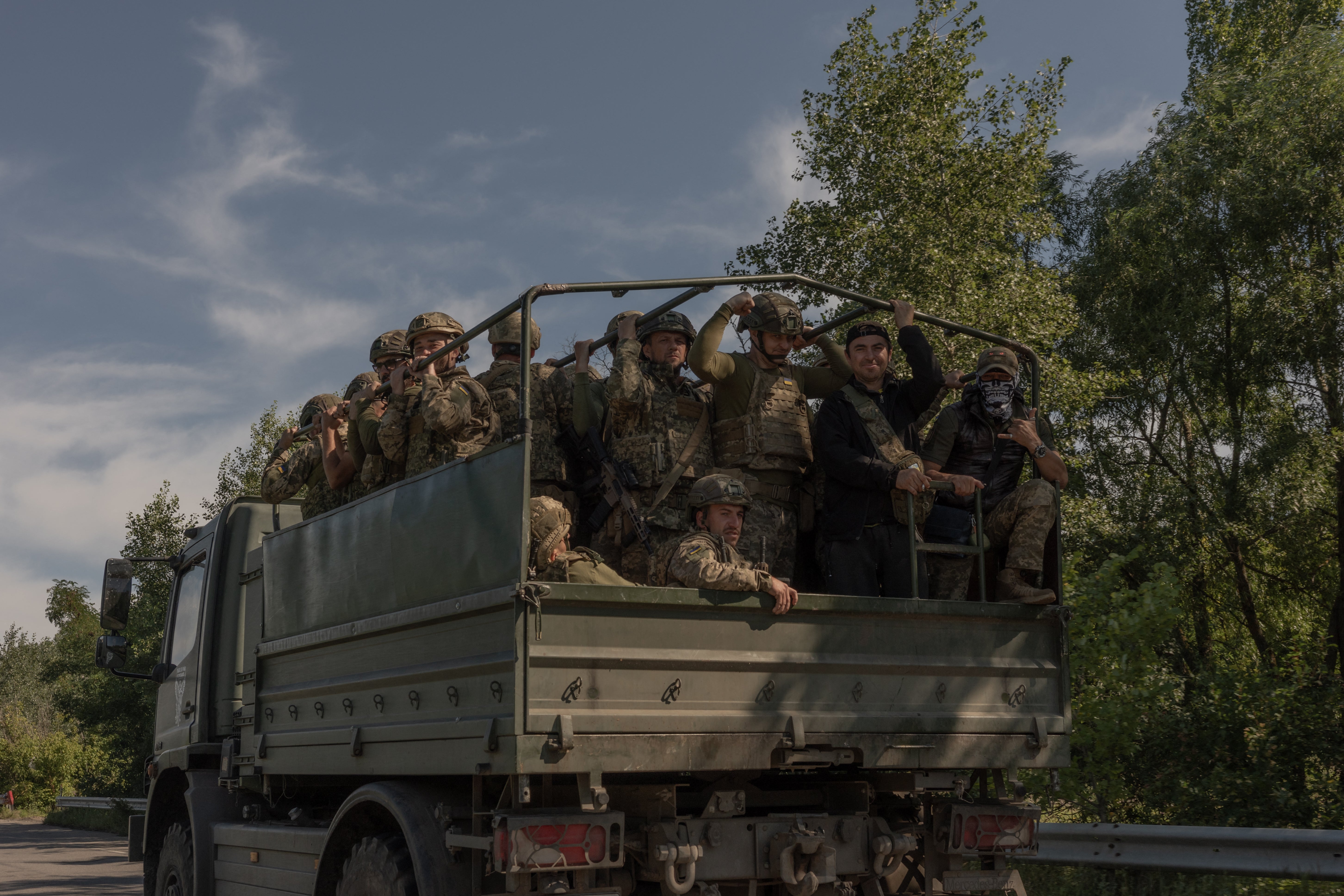Ukrainian soldiers drive in a military truck along a road in the Kharkiv region