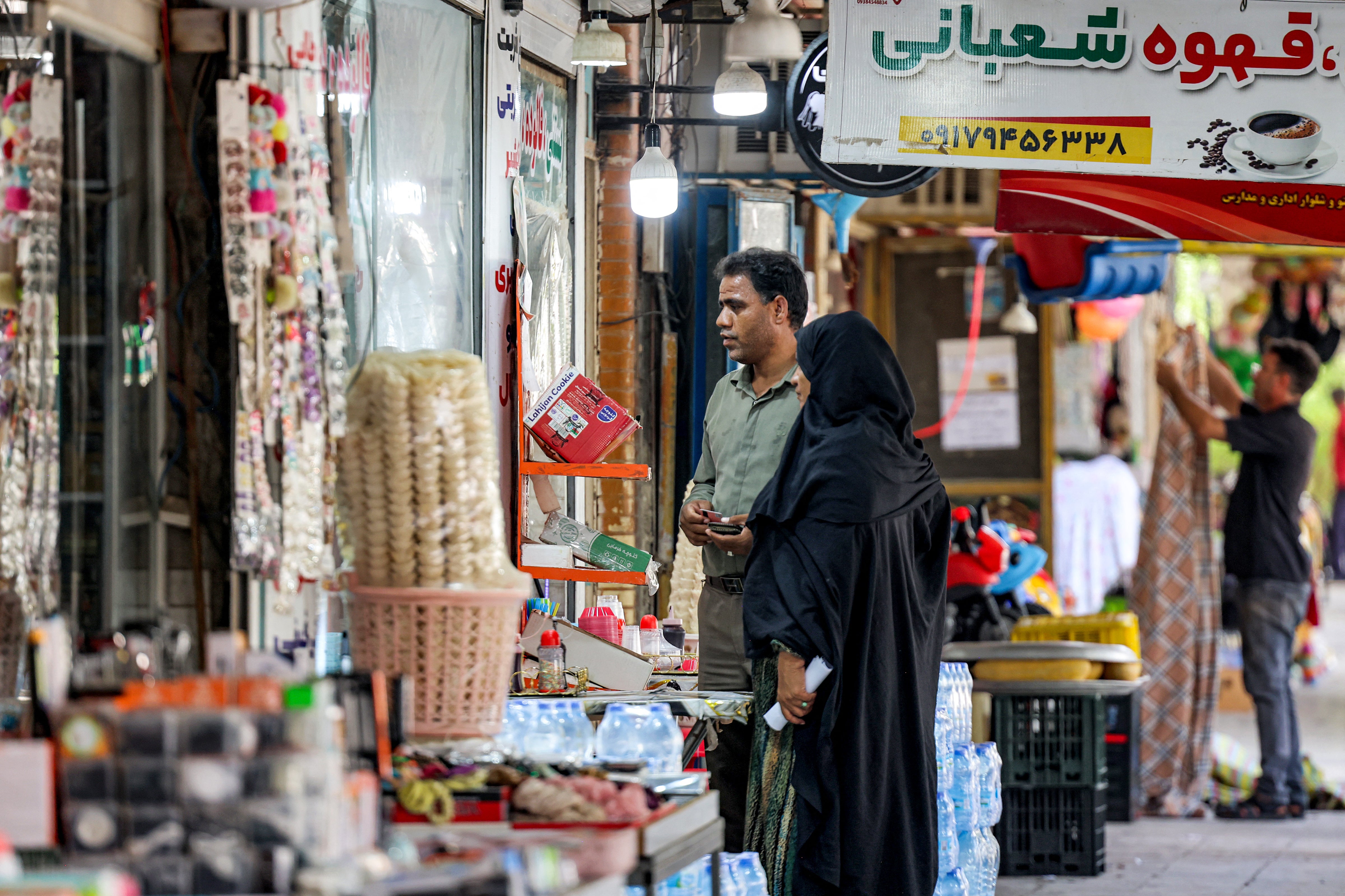 People shop at a market in Minab in Iran's southern Hormozgan province on August 10,