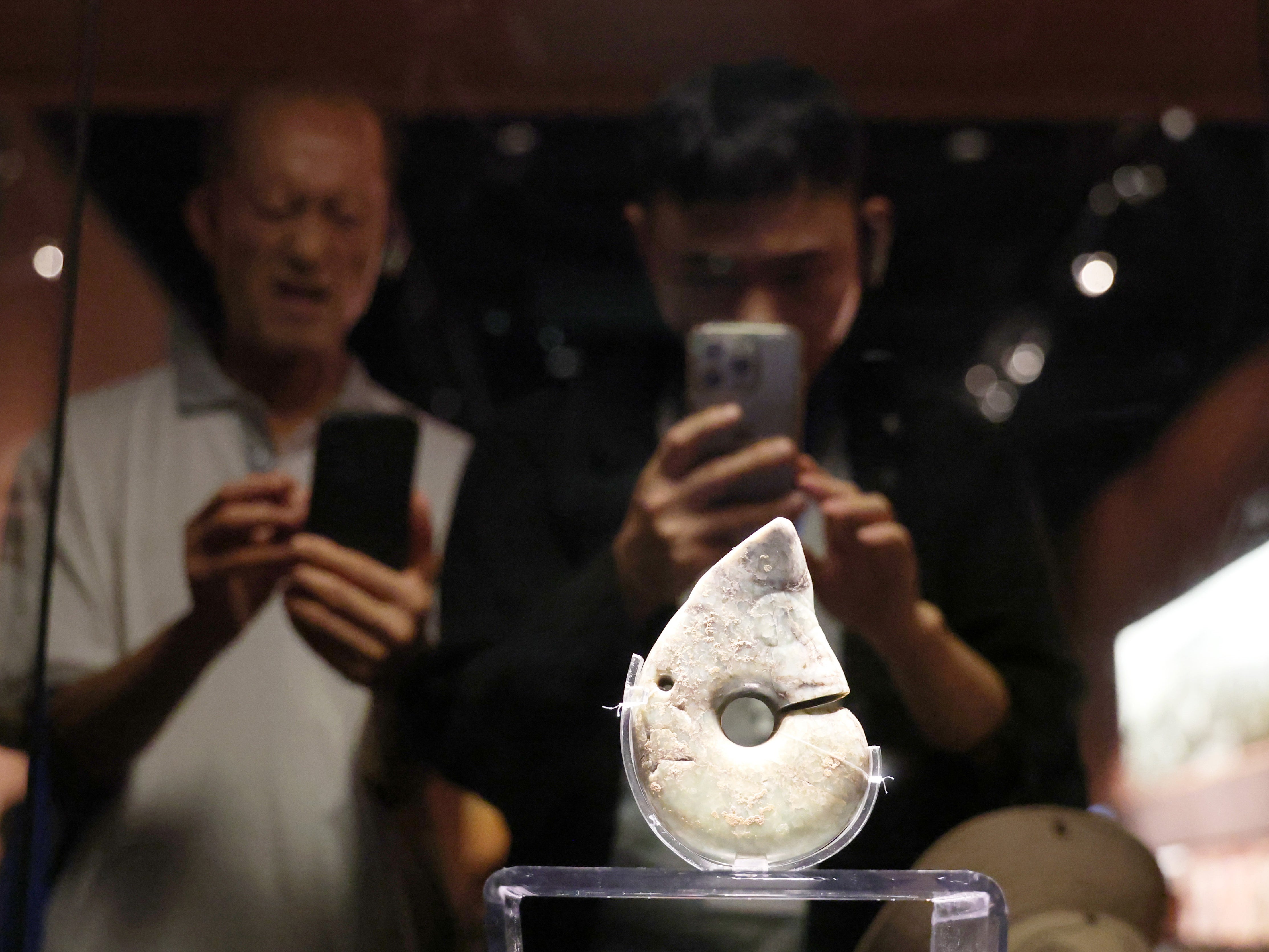 Visitors view a jade pig-dragon, one of the representative jade artefacts of Hongshan culture, at Niuheliang Site Museum in Chaoyang, on 4 August