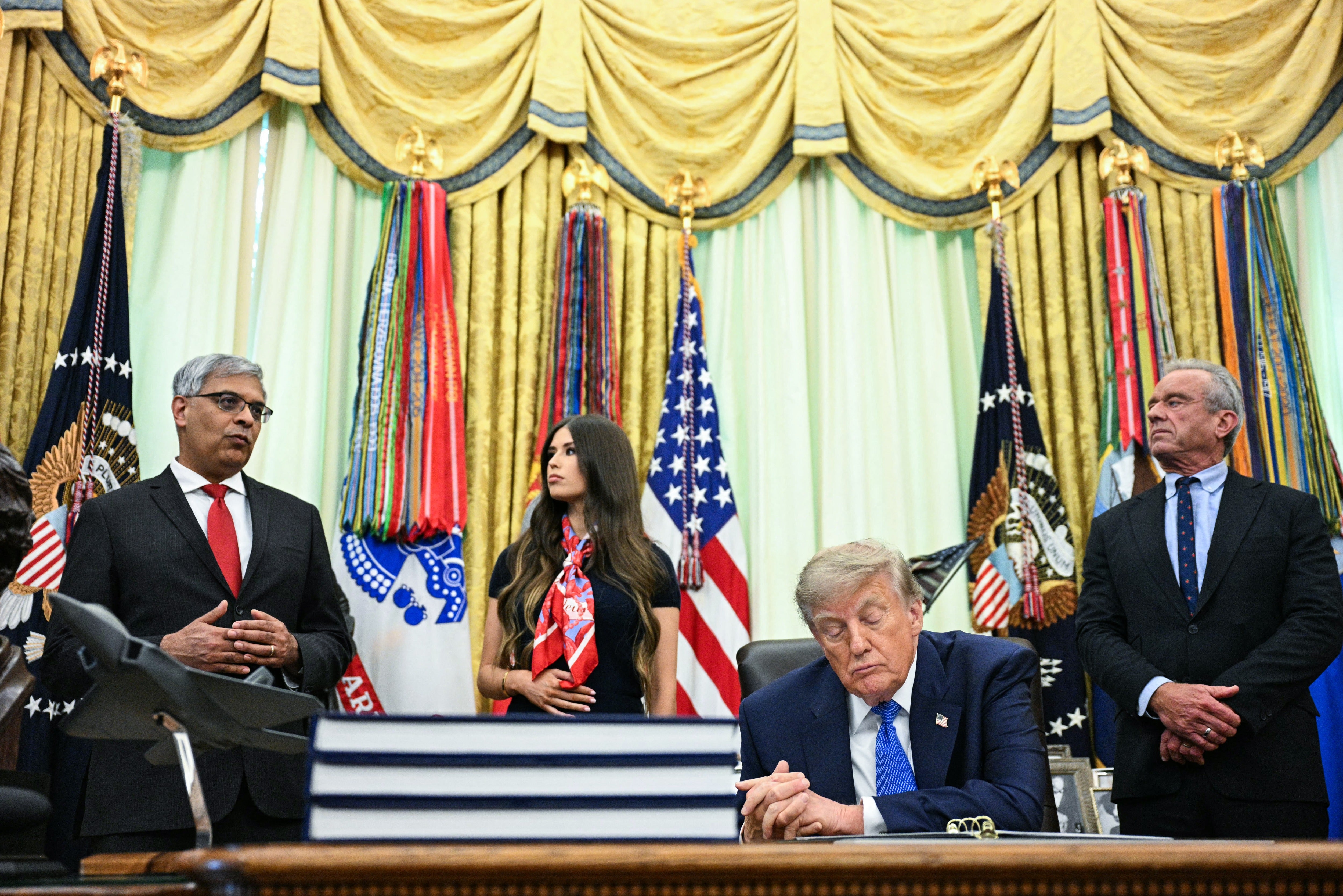 Director of the National Institutes of Health Jay Bhattacharya (L) speaks before President Donald Trump signs an executive order calling for more research and flexibility on vaccines