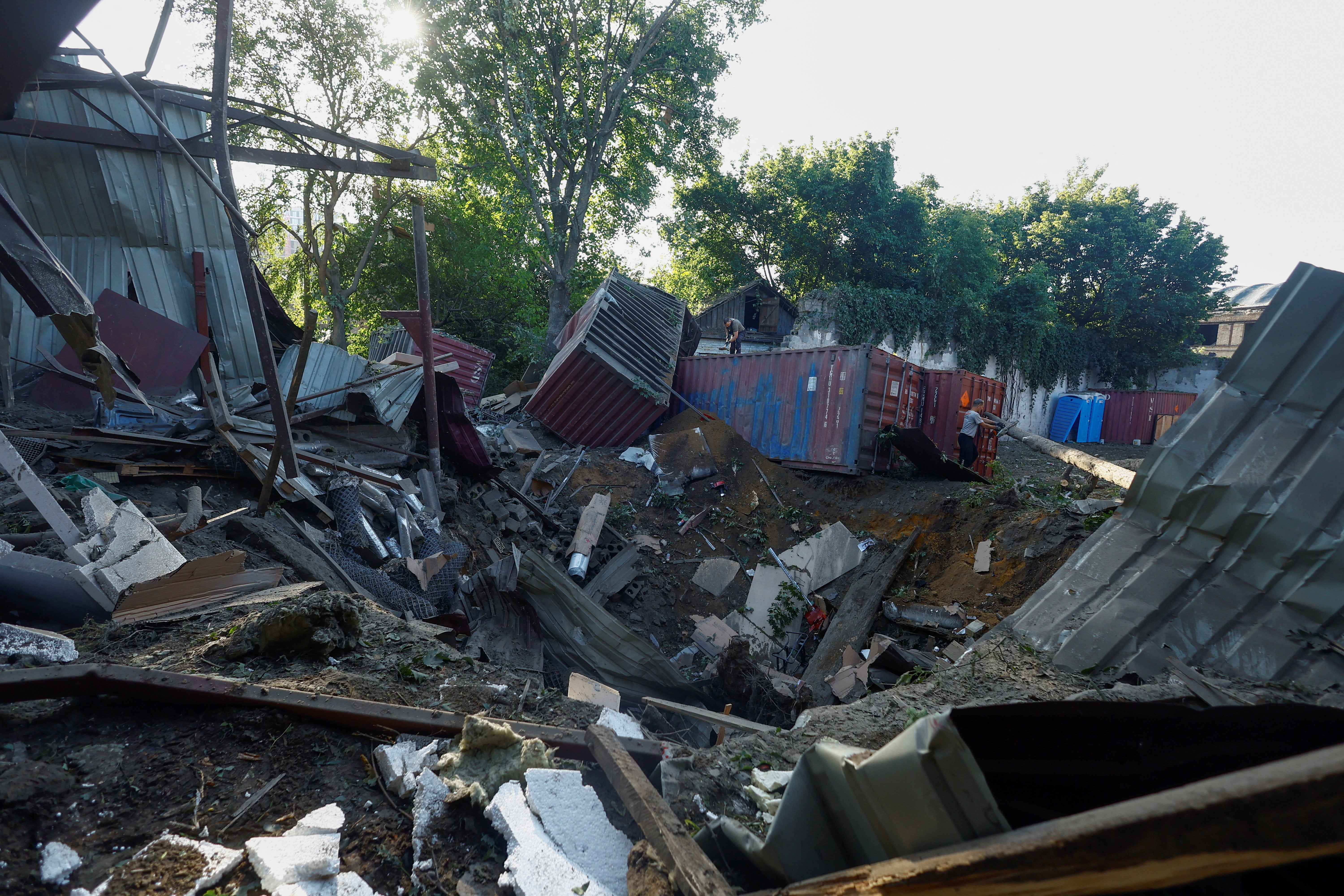 An employee removes debris at the compound of a City Children's Clinical Infectious Disease Hospital hit by an overnight missile strike