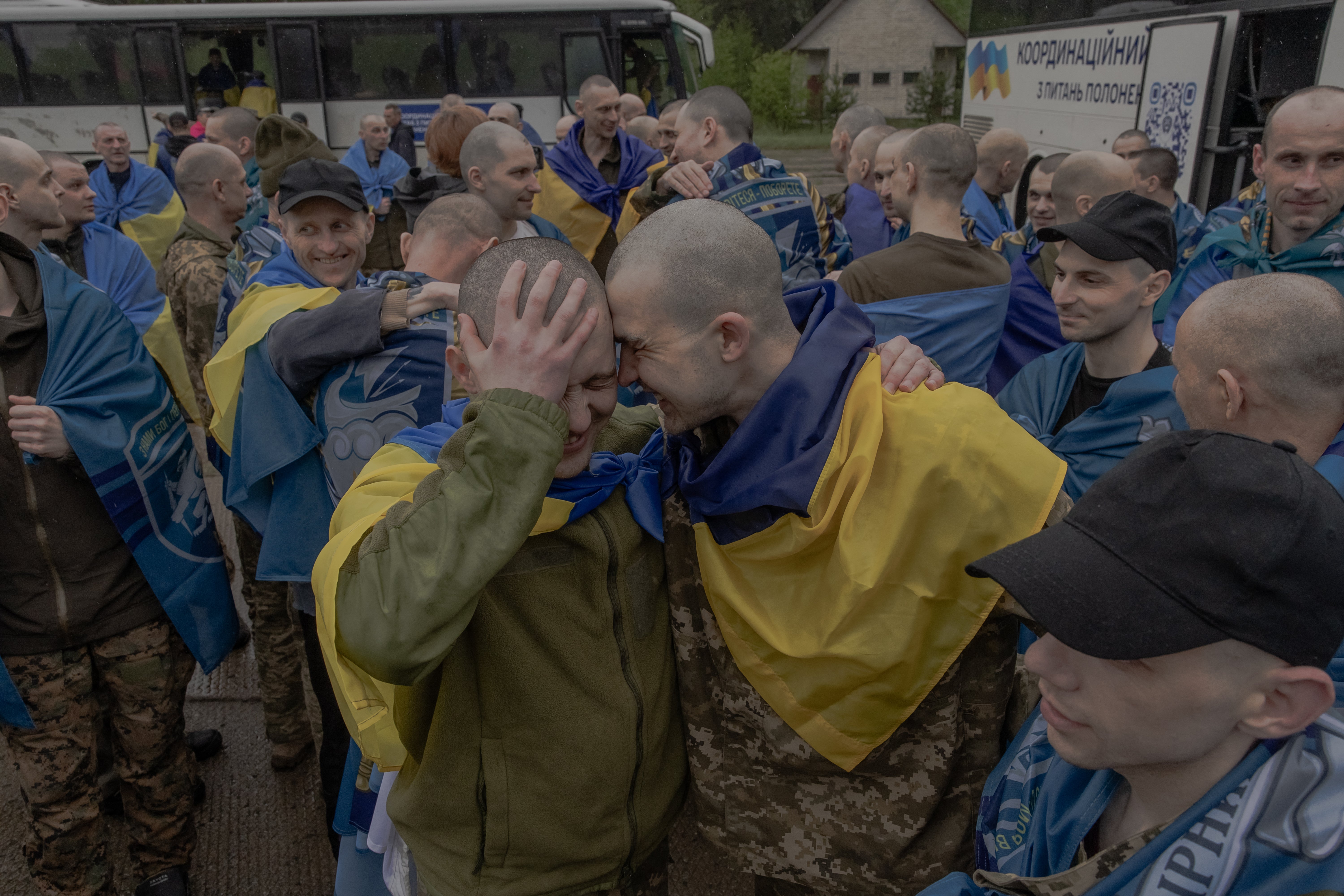 Released Ukrainian prisoners of war (POWs) embrace each other following a prisoner exchange at an undisclosed location, in the Chernihiv region
