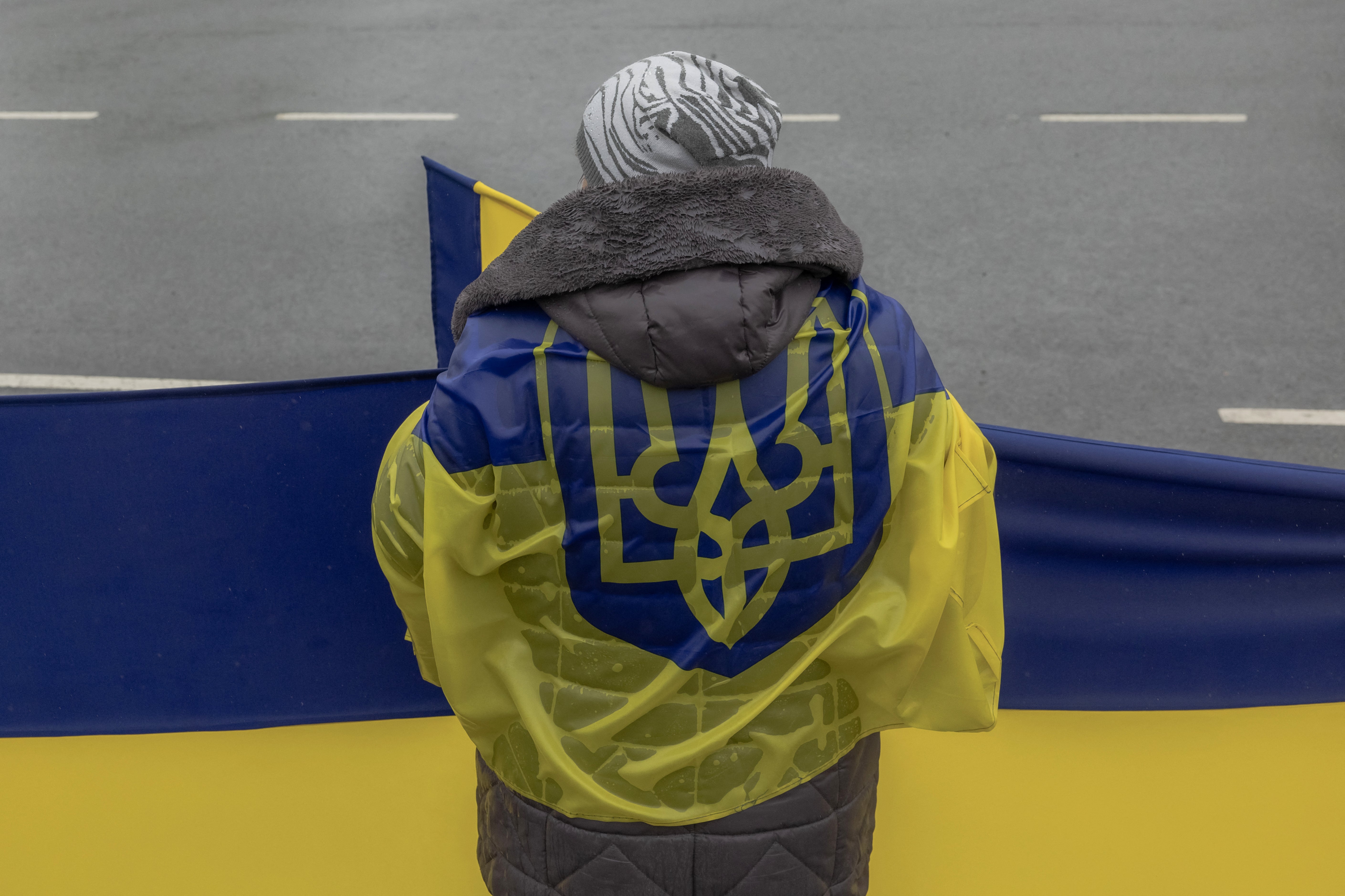 A woman waits along a road to greet released Ukrainian prisoners of war (POWs) following a prisoner exchange, in the Chernihiv region on May 15, 2026 (AFP/Getty)