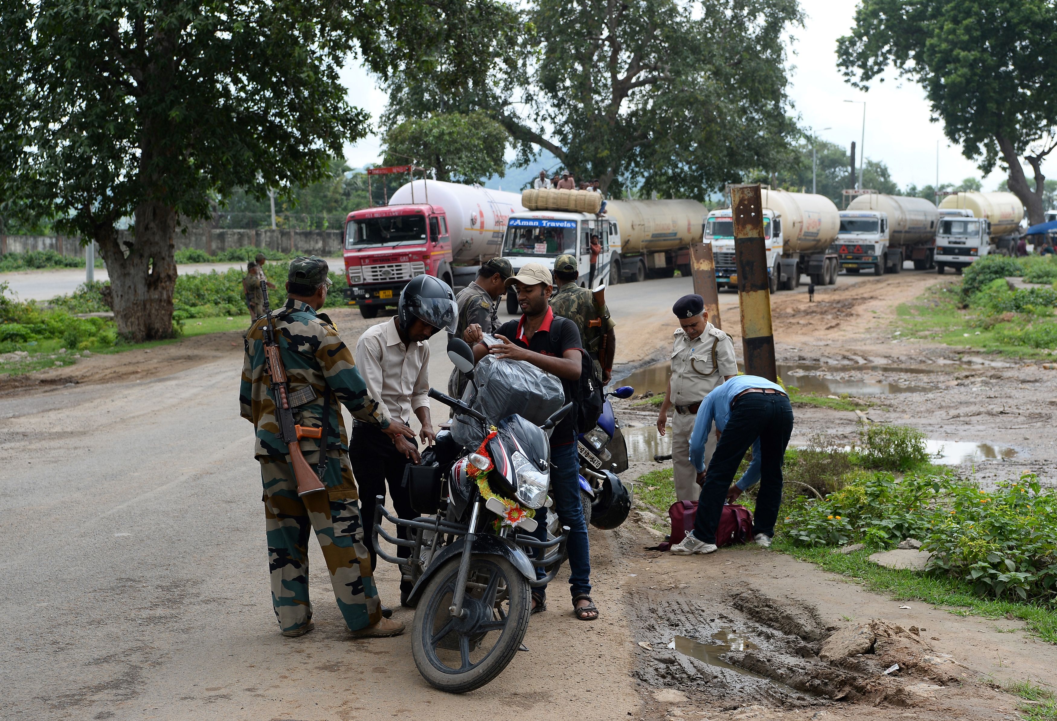 Indian excise department officers search for alcohol entering Bihar at a checkpoint in Rajauli, 150km south of Patna, on 20 August 2017 (AFP/Getty)