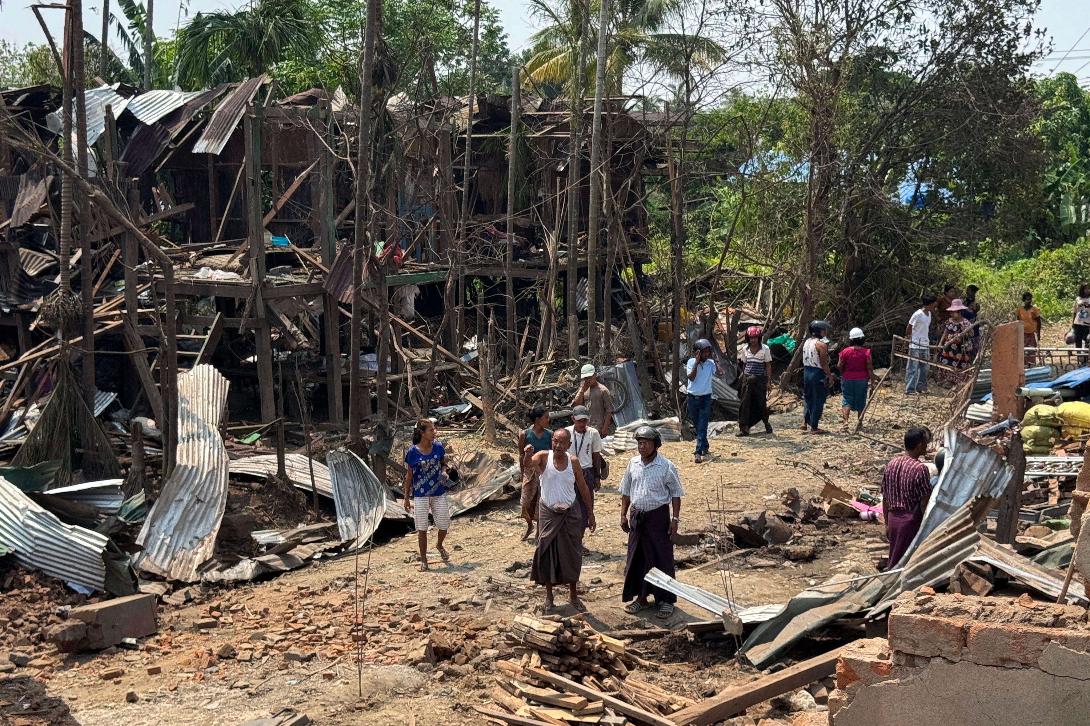 People walk past destroyed buildings following airstrikes in Kyauktaw town in western Rakhine state (AFP/Getty)