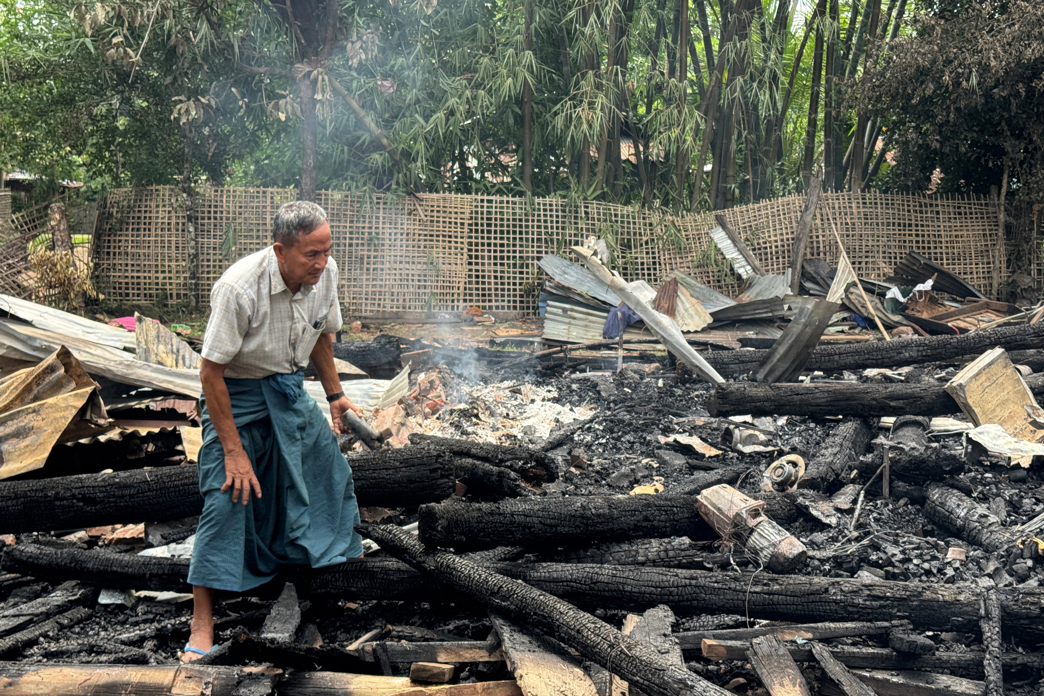 A man clears debris after an airstrike by Myanmar's military in Kyauktaw in western Rakhine state (AFP/Getty)