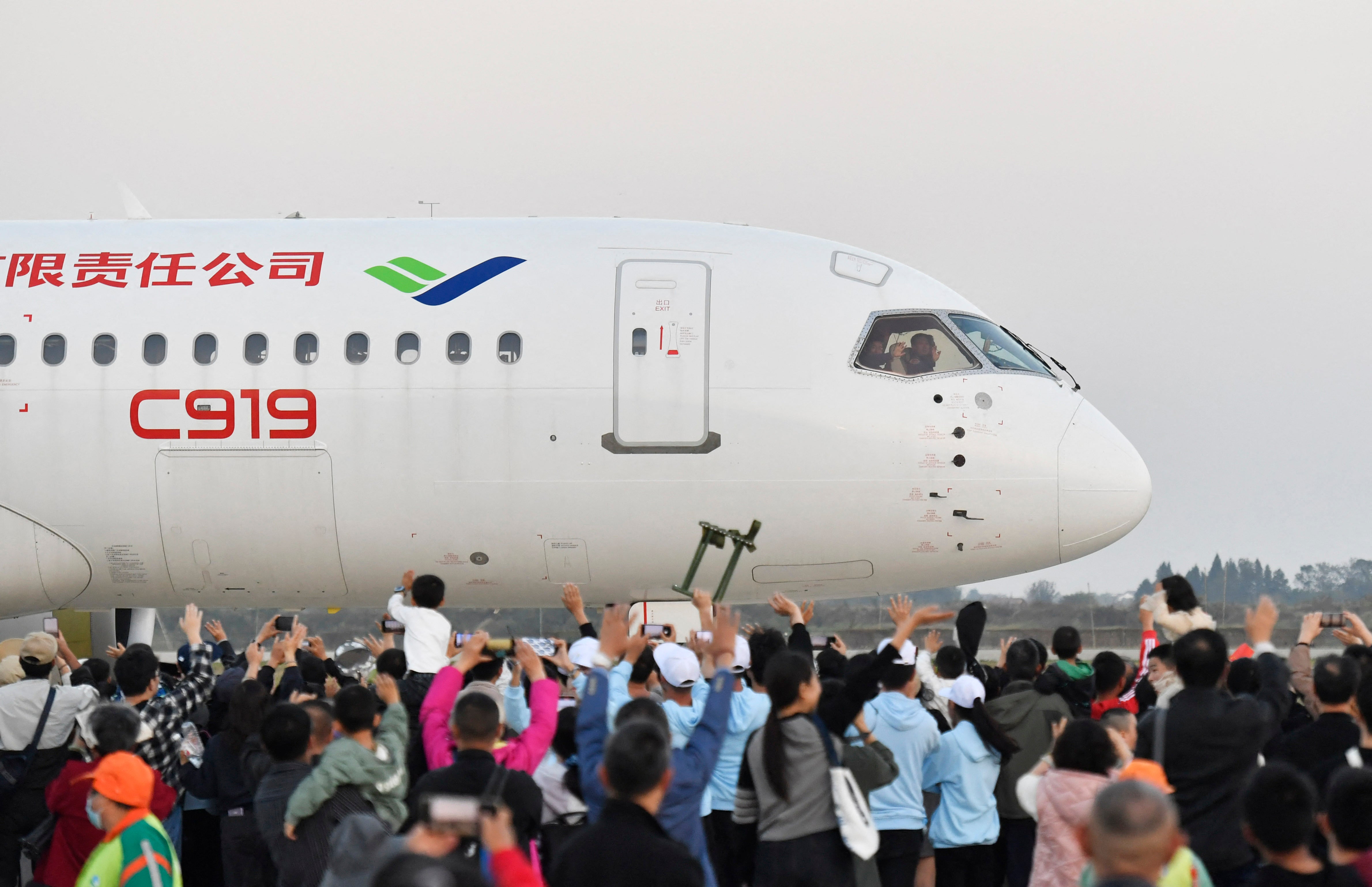 A crowd waves to pilots of China's domestically produced C919 passenger jet at an air show in Nanchang, Jiangxi, on 2 November 2024