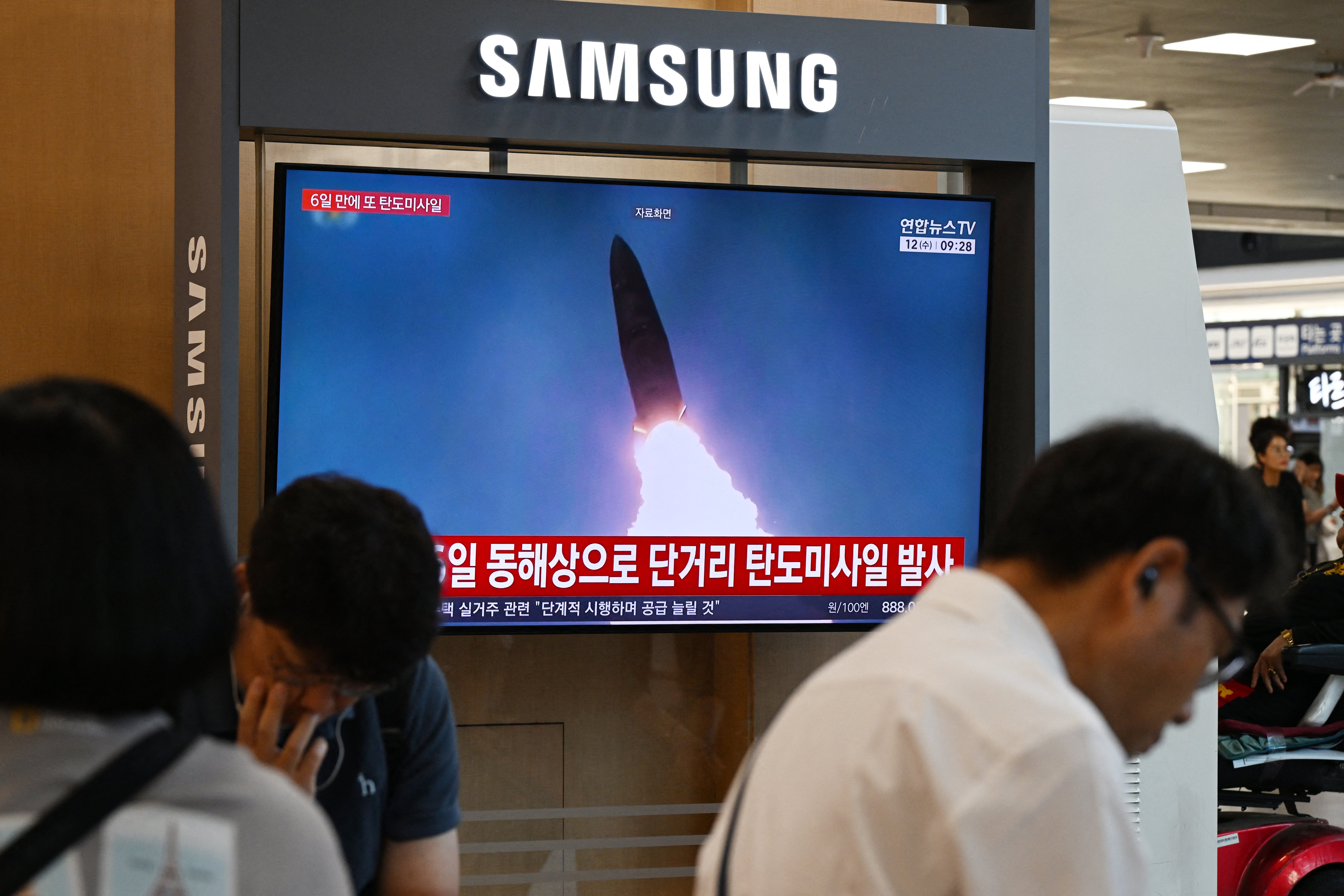 News coverage showing file footage of a North Korean missile launch is seen on a screen at Seoul Station in Seoul on August 12, 2026.