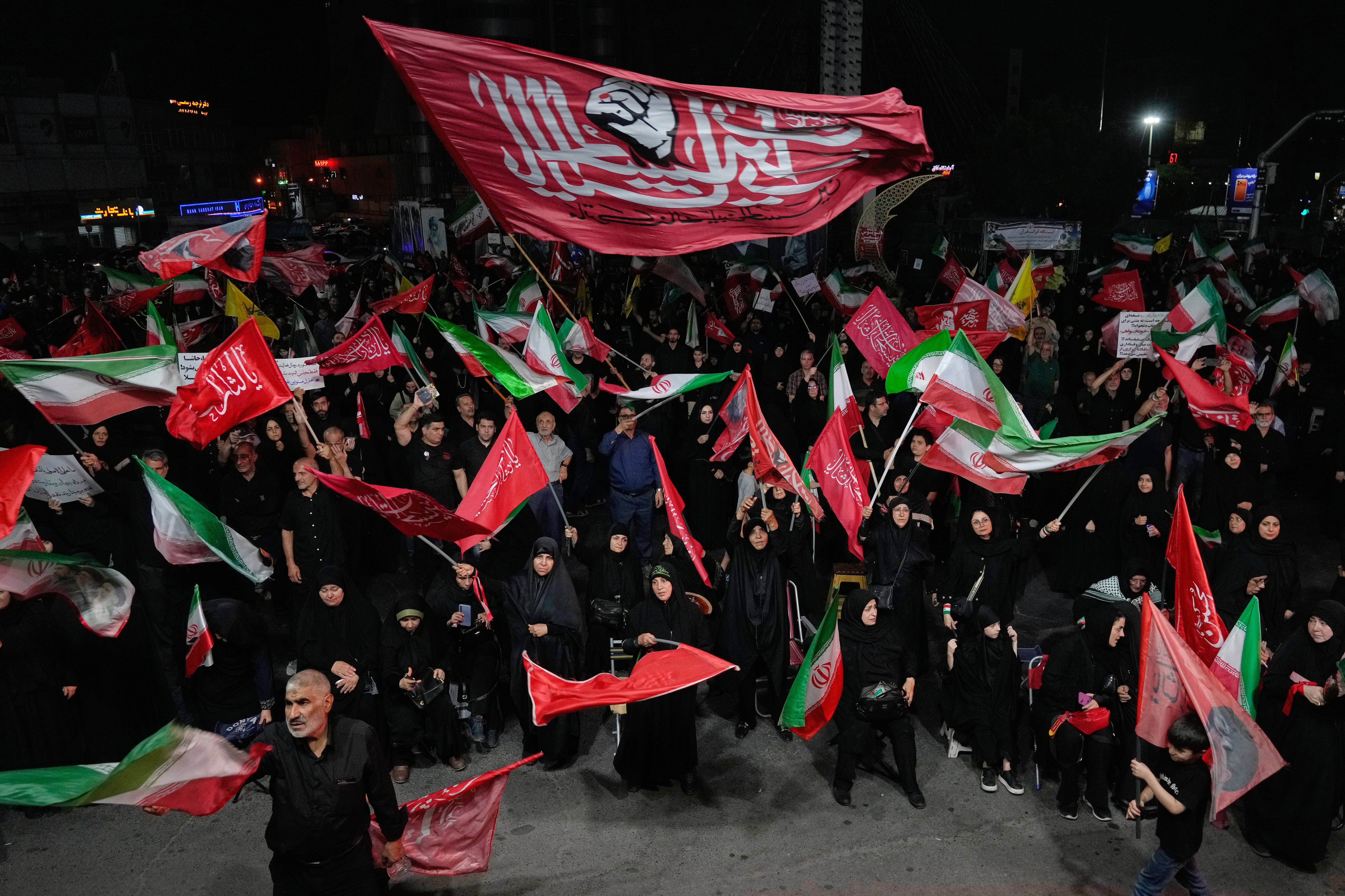 Iranian pro-government demonstrators wave flags in a gathering at a square in Tehran, Iran. The US and Israel appeared confident that strikes would prompt a regime change