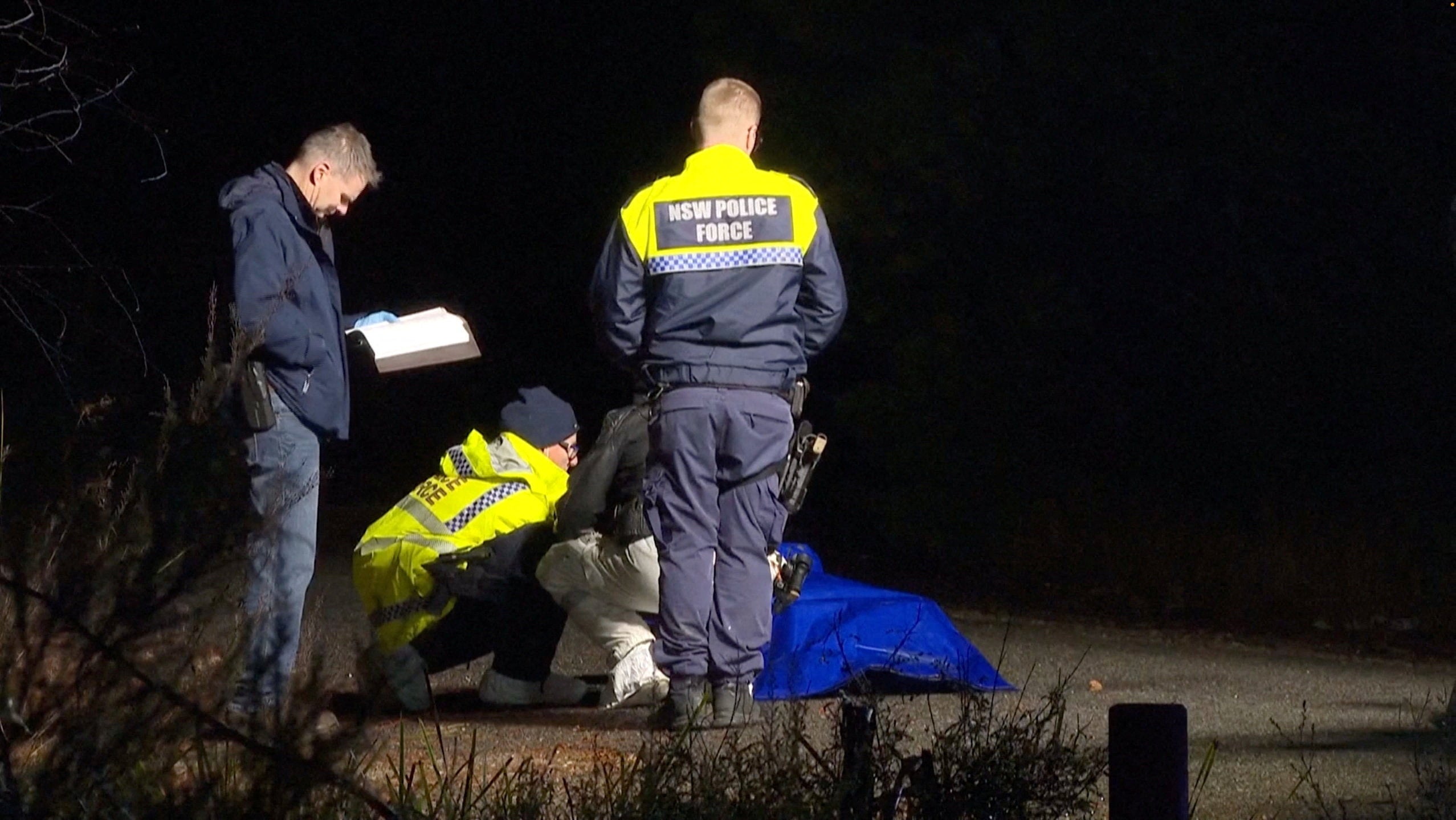 Police personnel handle a bag covered in plastic containing a lifelike doll (Reuters)