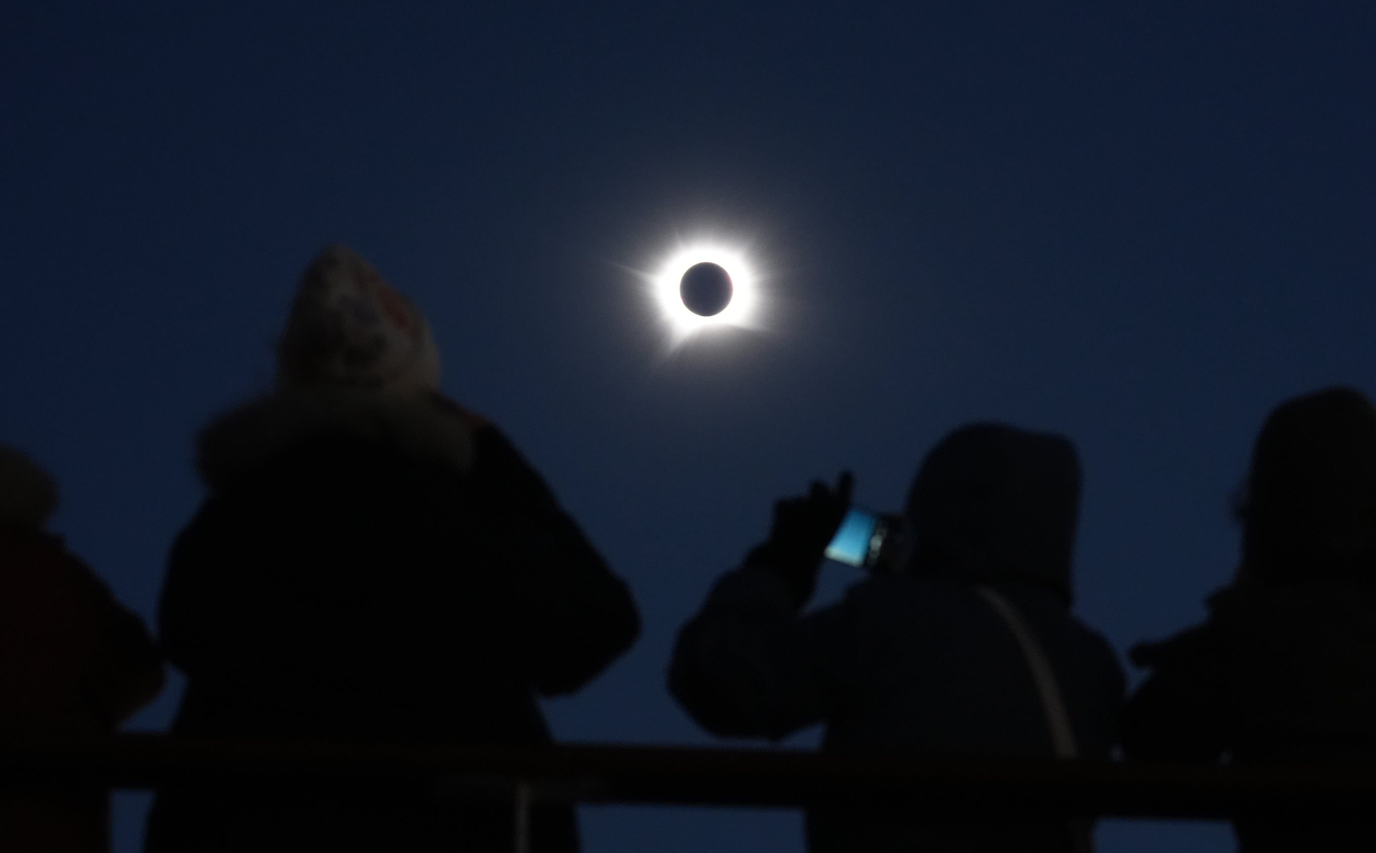 Cruise passengers take in the total eclipse from a cruise ship off the coast of Greenland