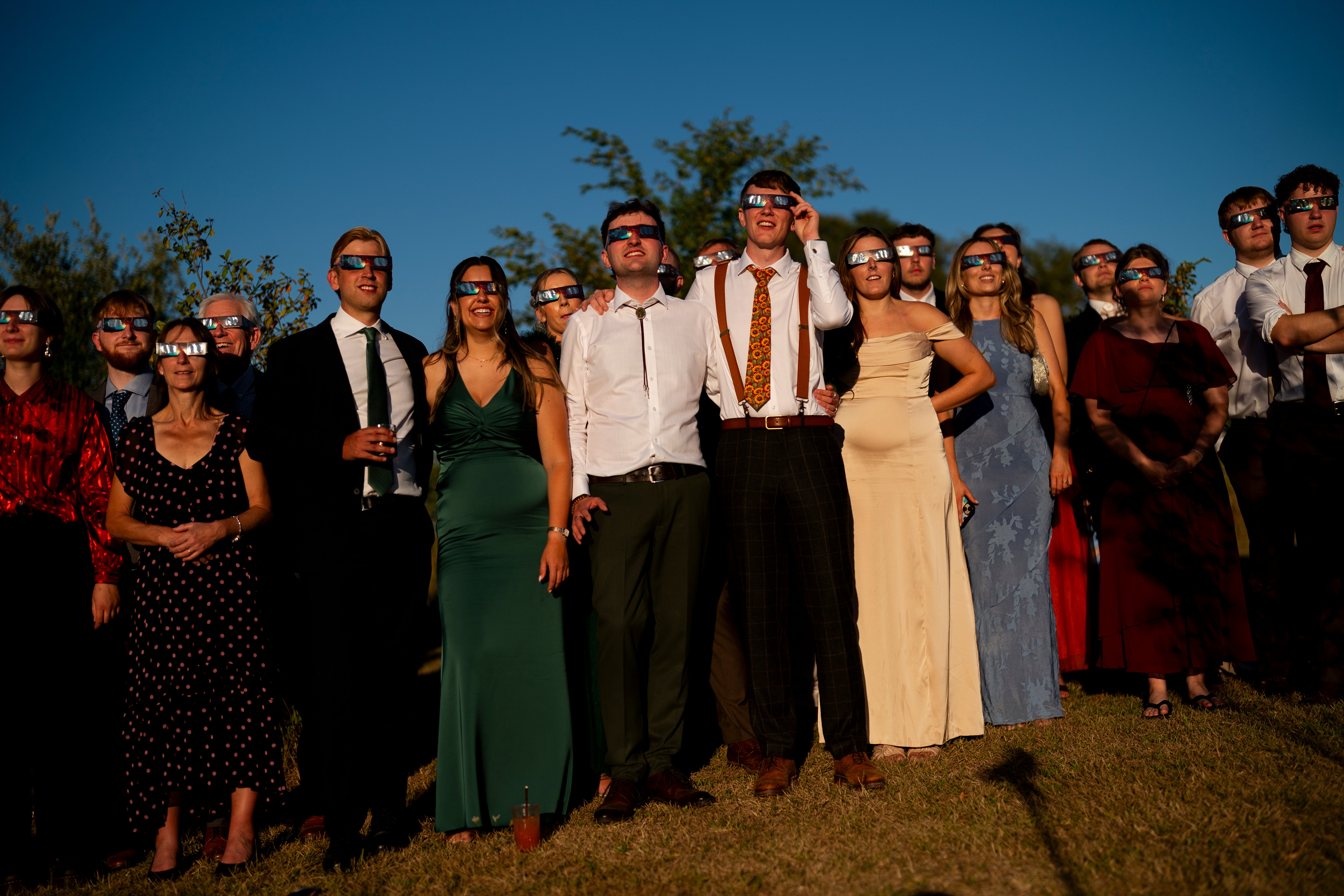 TWedding guests watch the solar eclipse at Alpheton in Suffolk (PA)