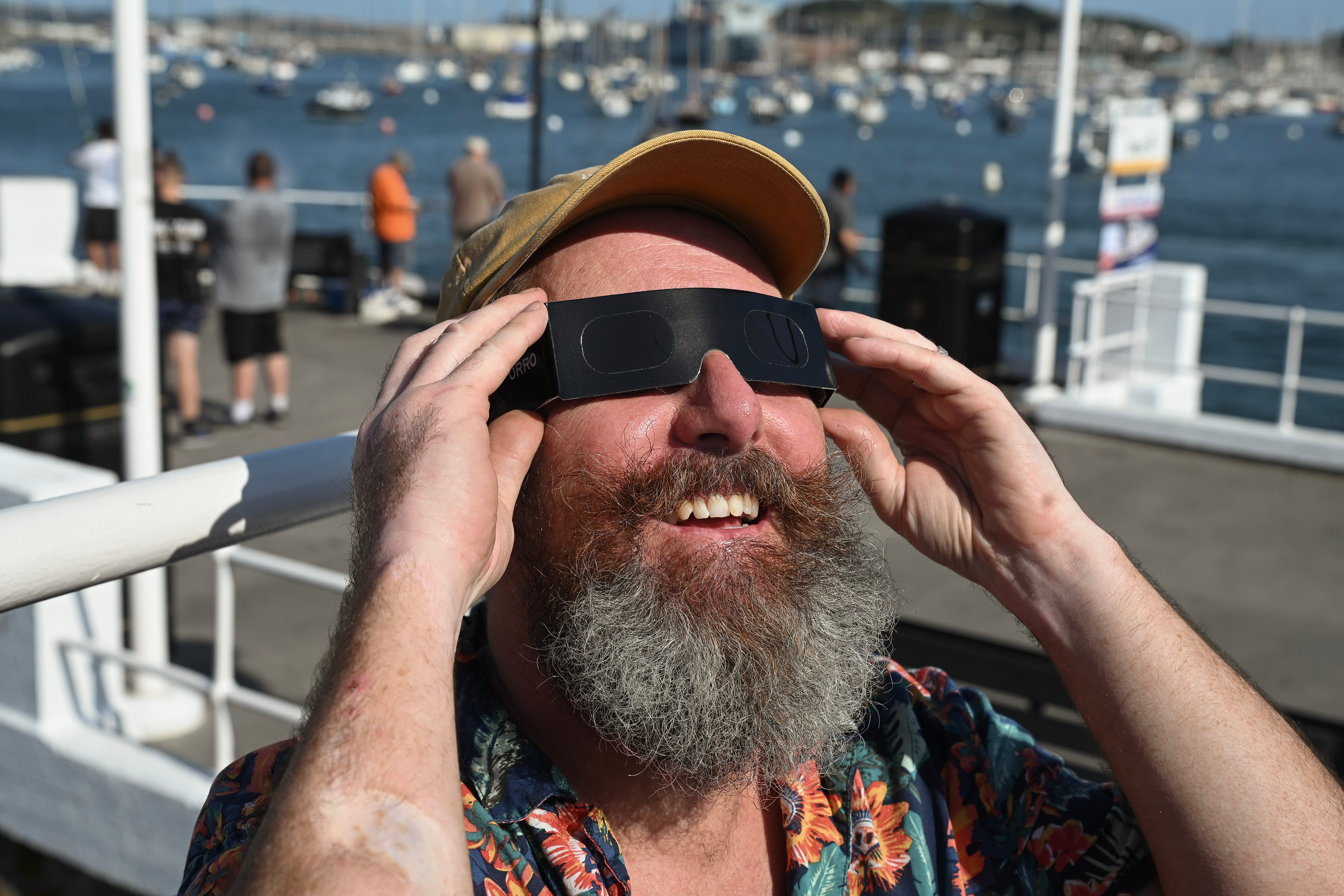 A passenger on board the Princessa pleasure boat try out their solar eclipse glasses on August 12, 2026 in Falmouth, England (Getty)