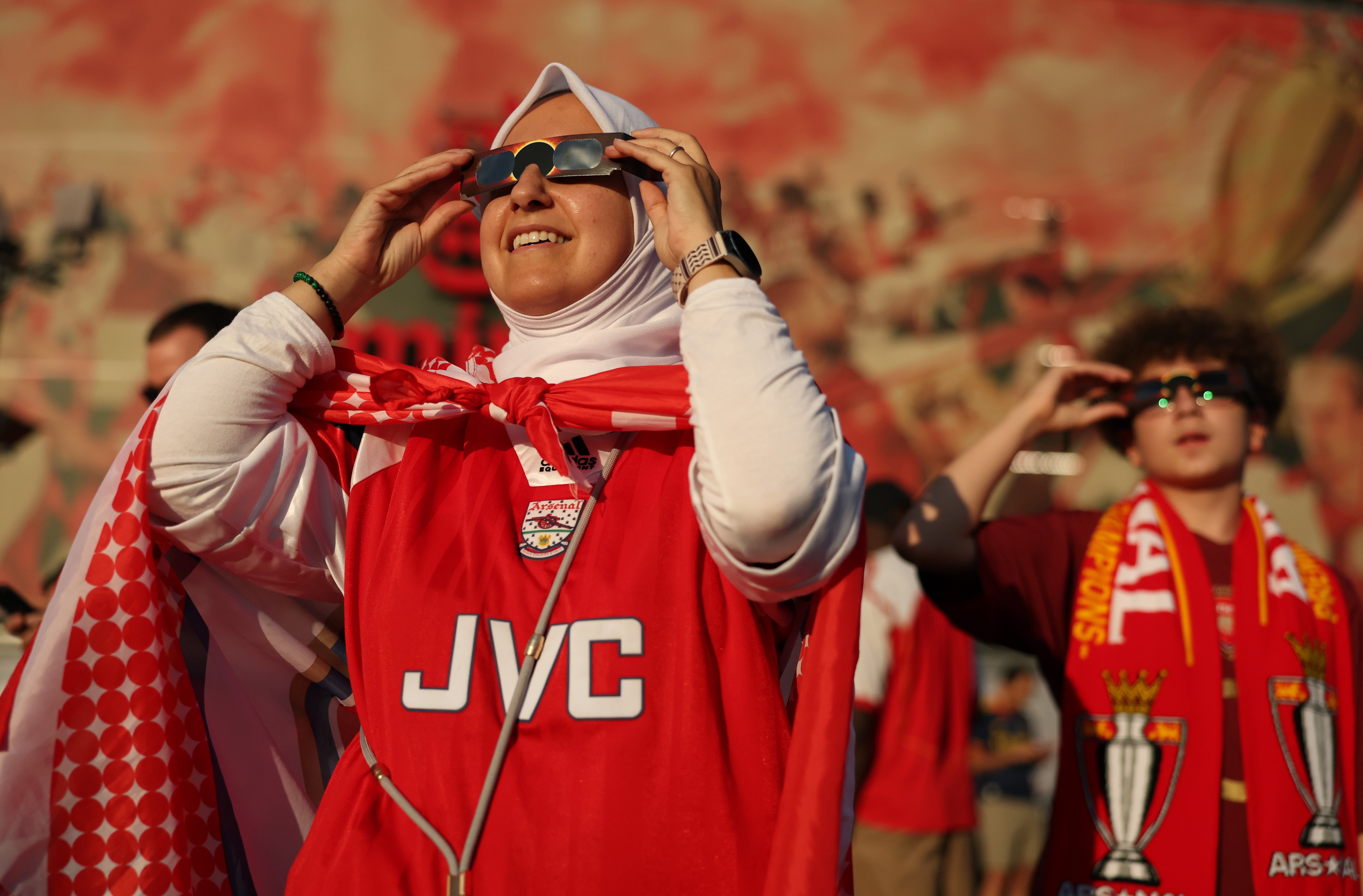 An Arsenal fan uses eclipse shades to view the solar eclipse prior to the pre-season friendly match (Getty)