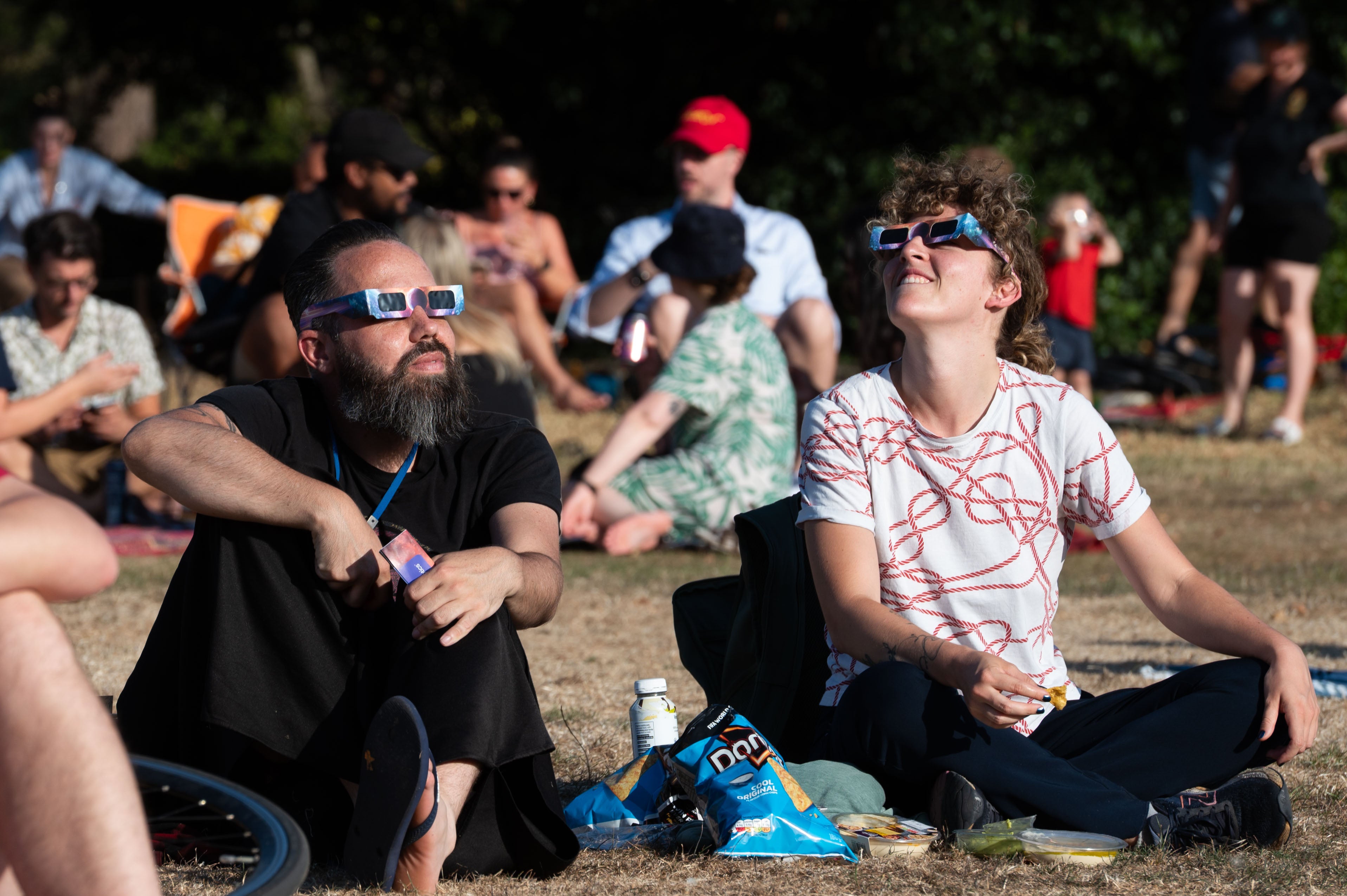 Members of the public wear protective glasses while watching a partial solar eclipse (PA)