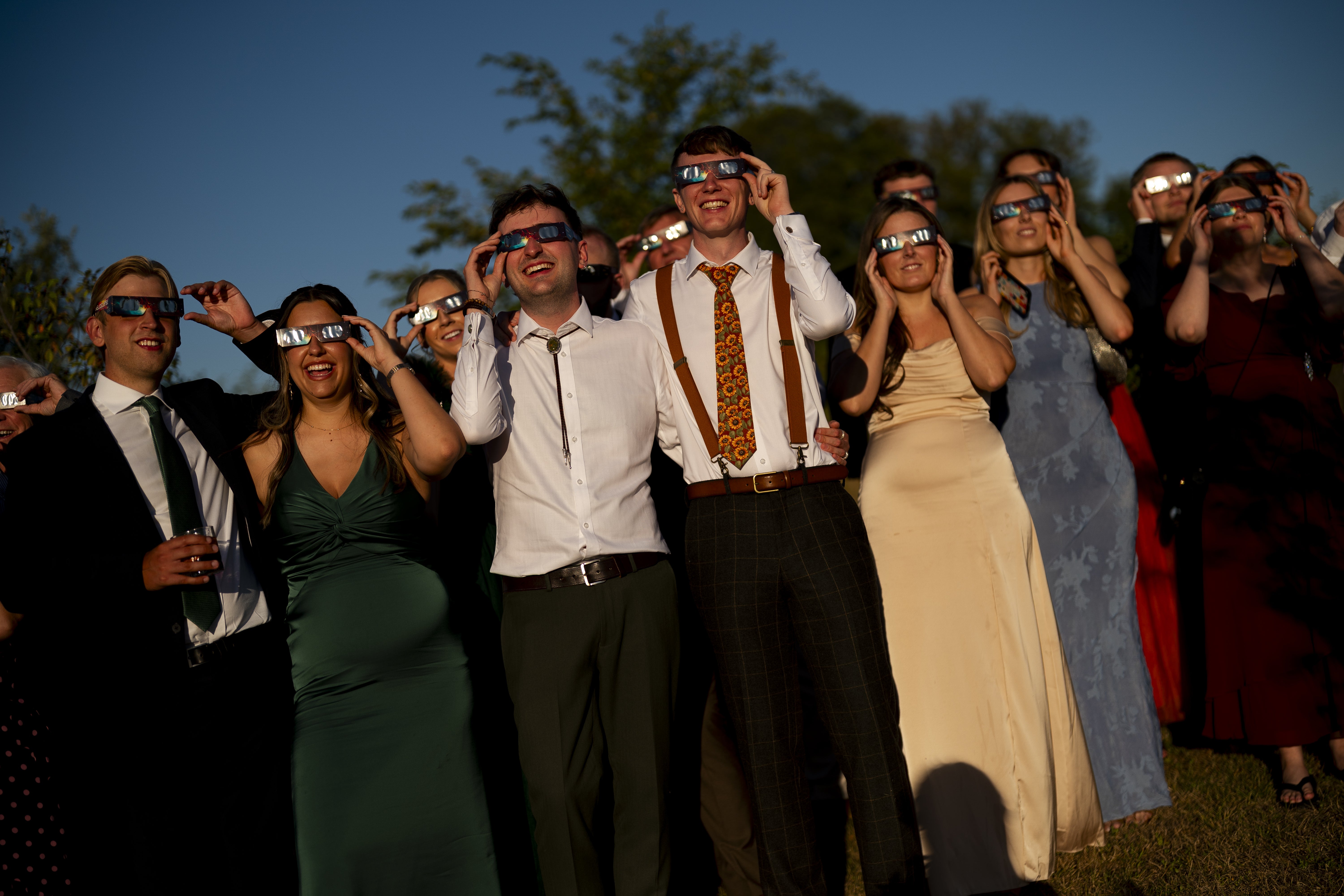 The wedding guests watch the solar eclipse at Alpheton in Suffolk (Jordan Pettitt/PA)
