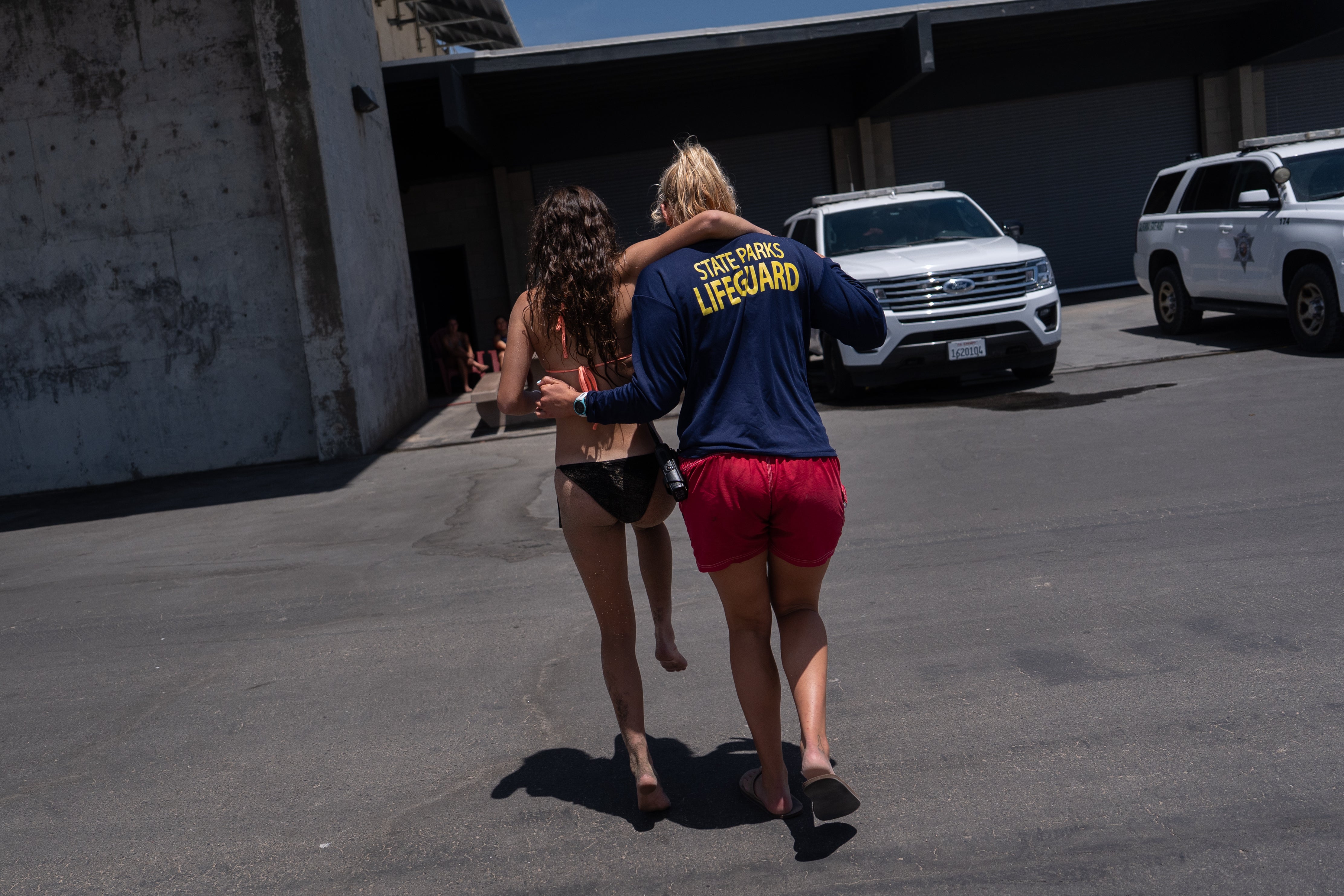 Lifeguard II Rachael Kowalchick assists a person stung by a stingray to the lifeguard headquarters for treatment at Bolsa Chica State Beach in Huntington Beach, Calif., Friday, July 24, 2026. (AP Photo/Jae C. Hong)