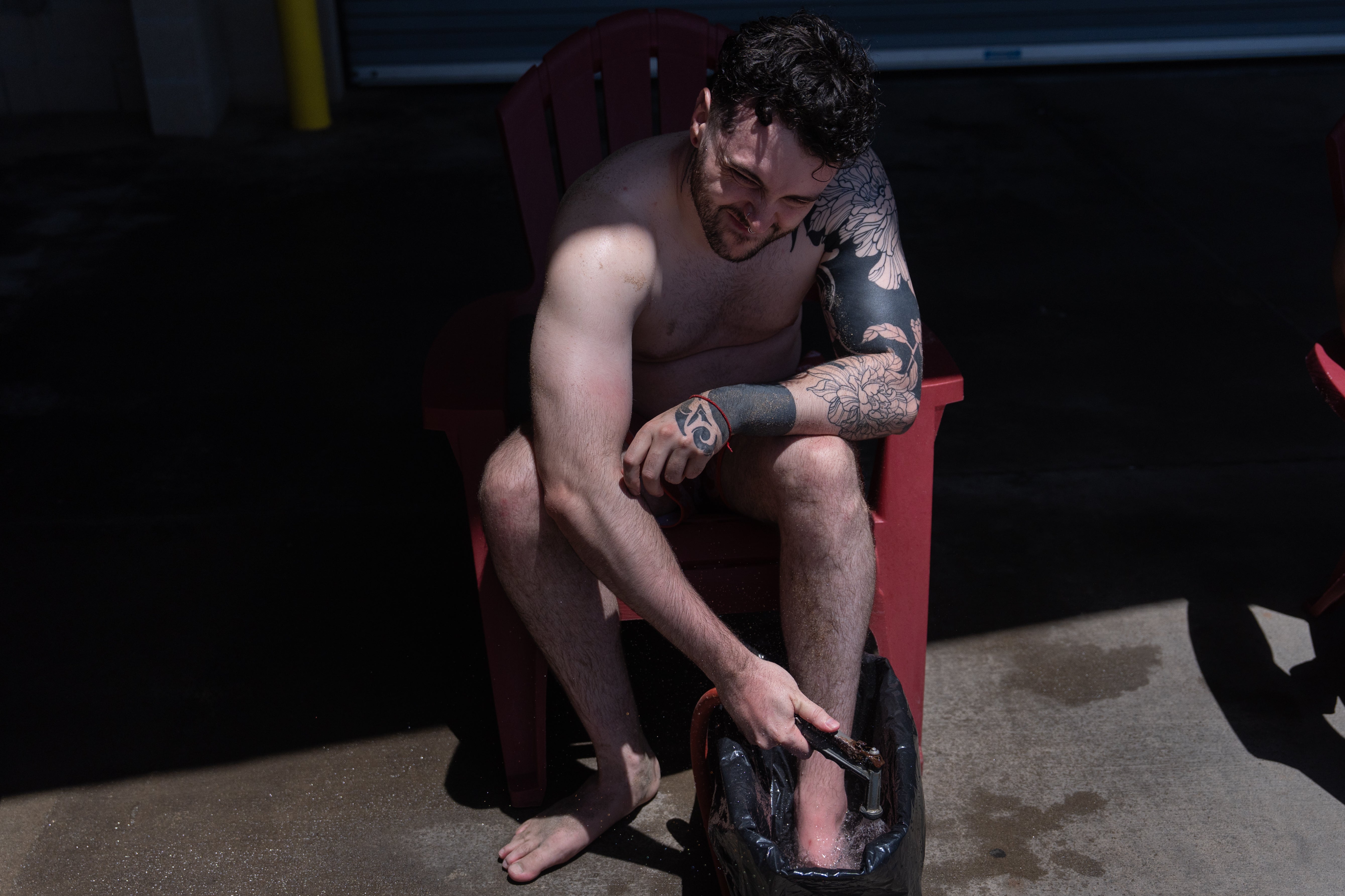 Jacob Hemann grimaces as he adds hot water to a bucket as he gets treatment for a stingray sting at Bolsa Chica State Beach in Huntington Beach, Calif., Friday, July 24, 2026. (AP Photo/Jae C. Hong)