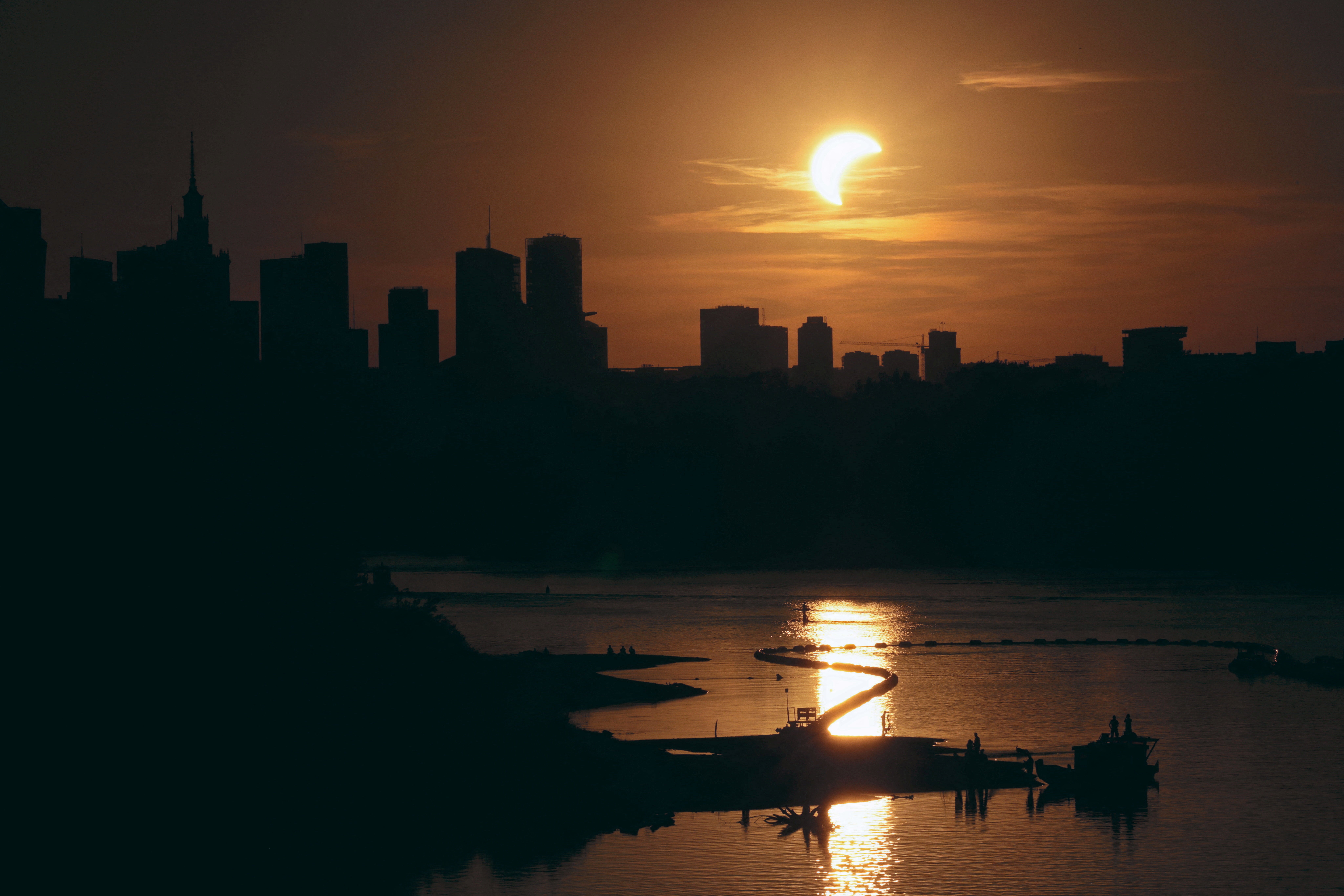 The sun over the skyline during a partial solar eclipse in Warsaw, Poland, August 12, 2026 (Reuters)