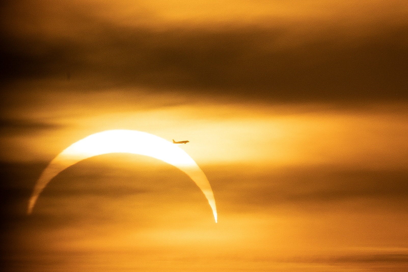Airplane pass the sun as the moon partially covers during a solar eclipse ,as seen from Prague, Czech Republic, August 12, 2026 (Reuters)