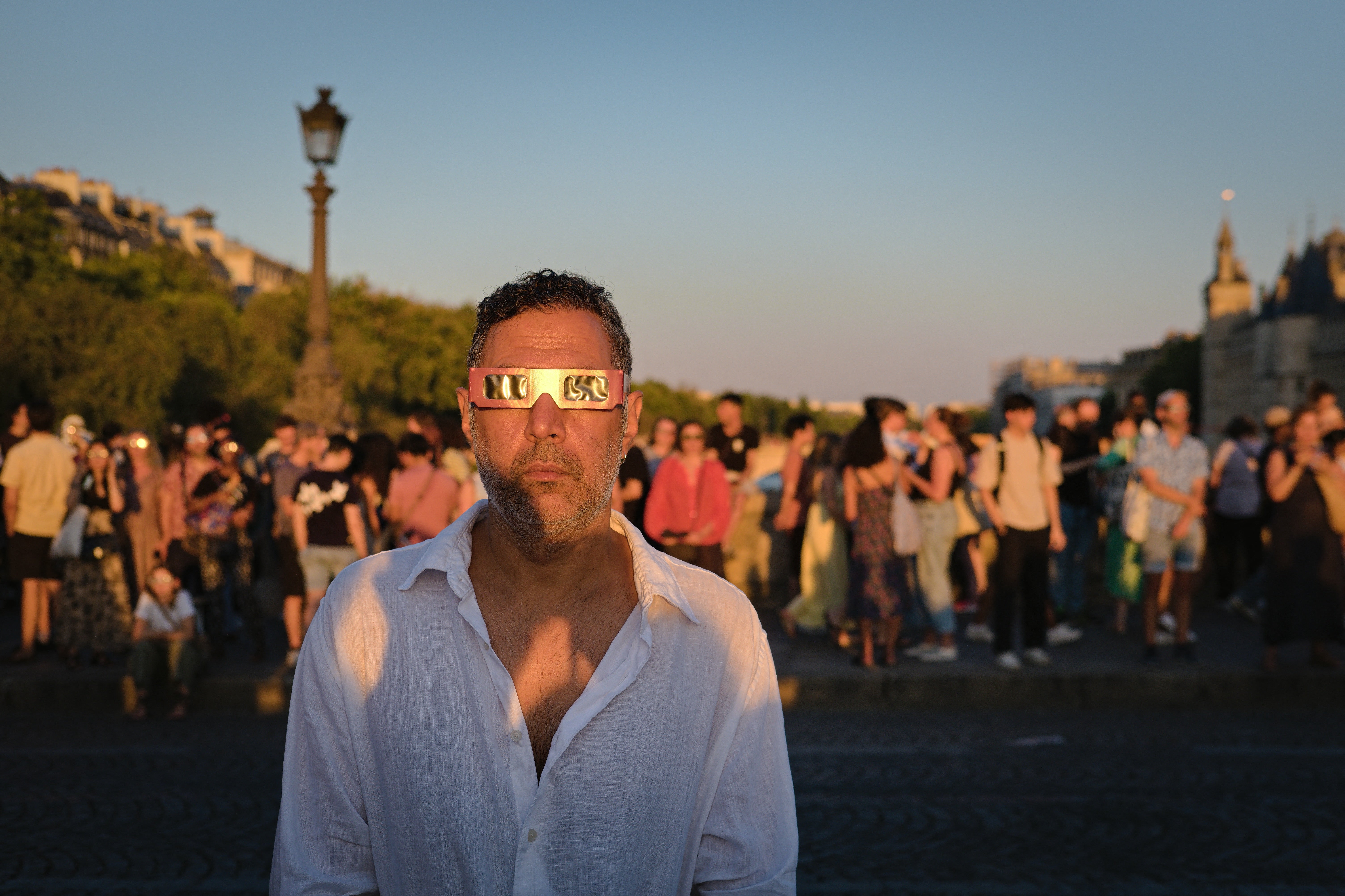 View of people wearing protective solar eclipse glasses while observing the Sun from Pont Neuf in Paris, Ile de France, France on August 12, 2026 (AFP/Getty)