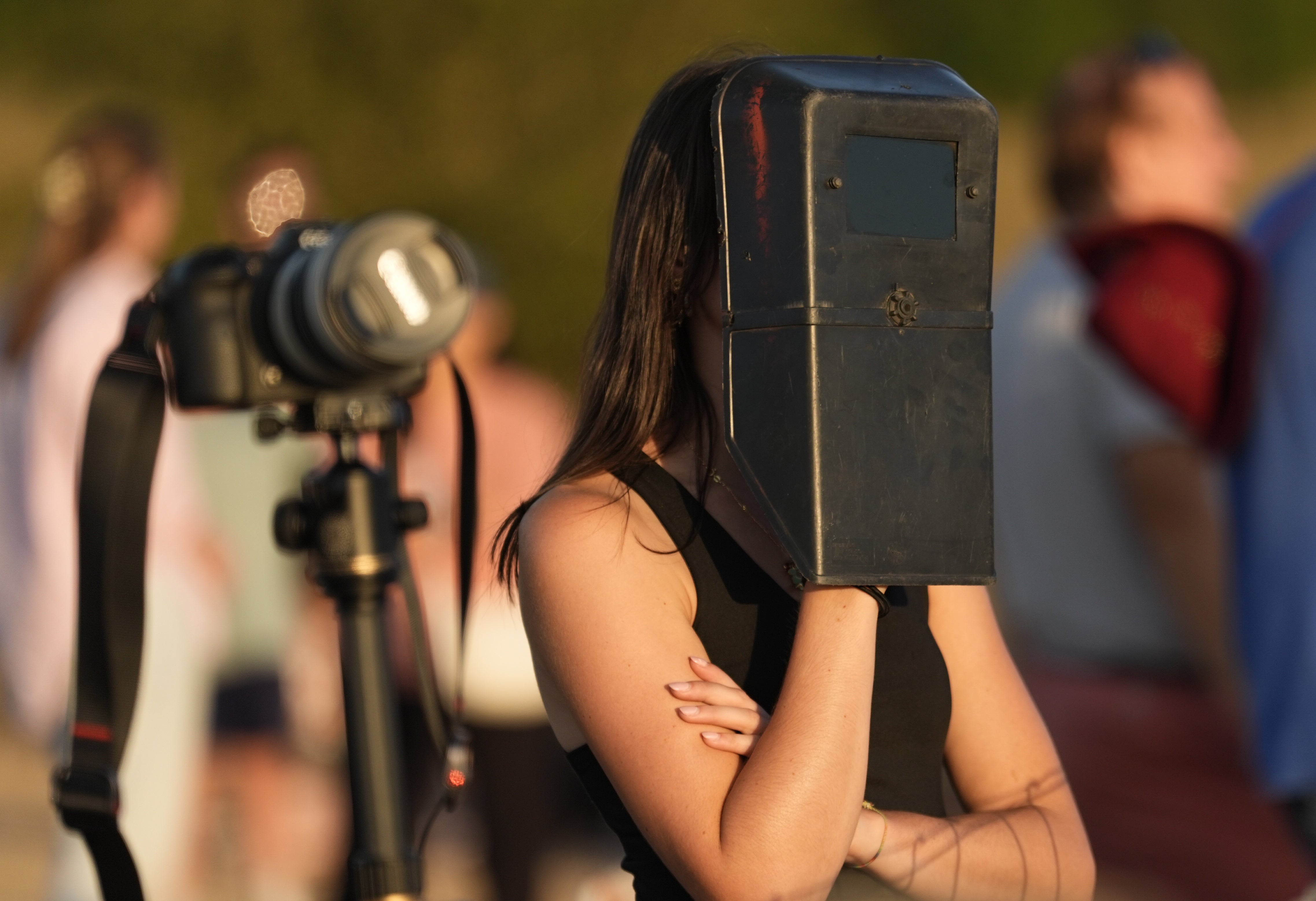 A person uses a welding mask to watch the solar eclipse at Stonehenge in Wiltshire (Andrew Matthews/PA)